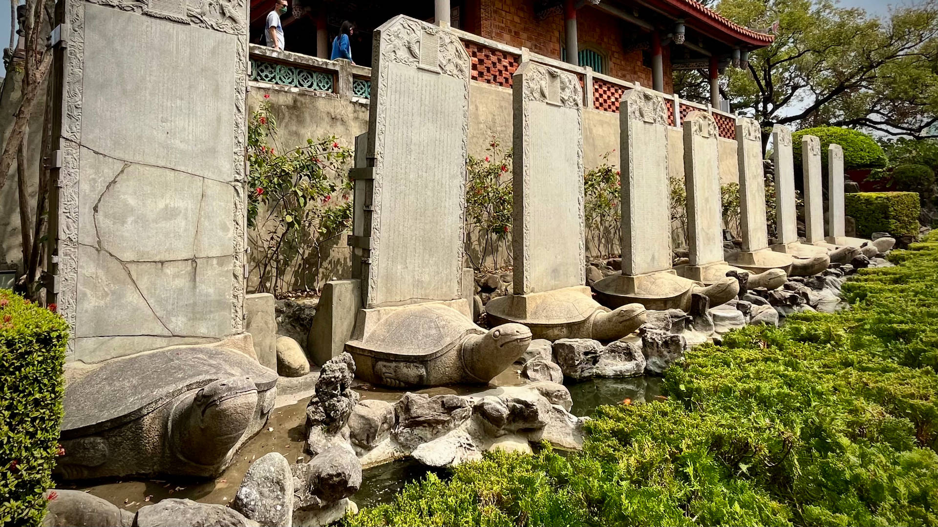 Nine statues of bixi (half-dragon, half-tortoise) creatures carrying upright stone tablets on their backs.