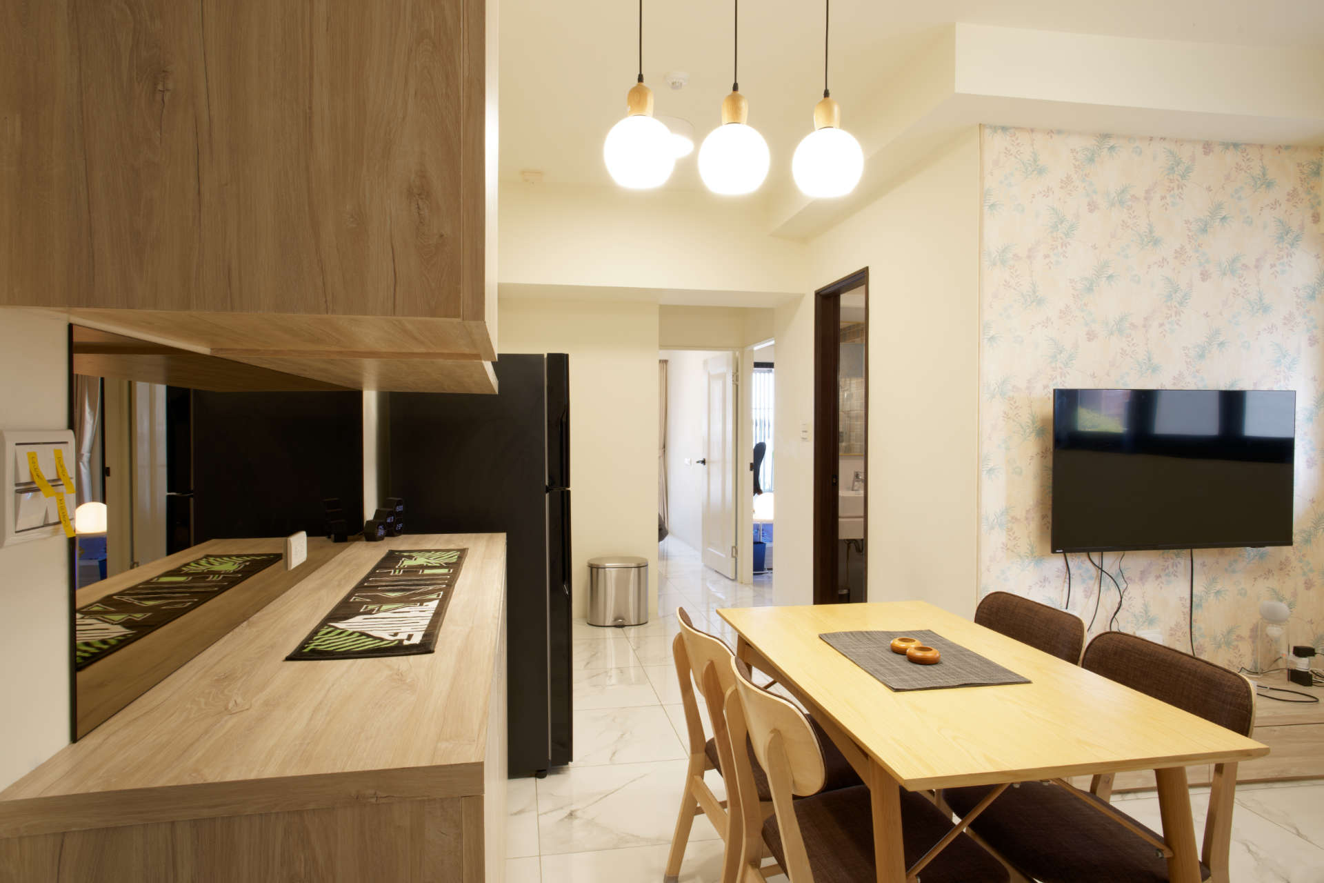 A dining area including a table and four chairs, and a wall-mounted console.