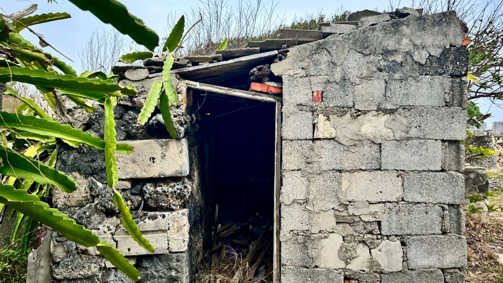 An abandoned building constructed of concrete and coral blocks.