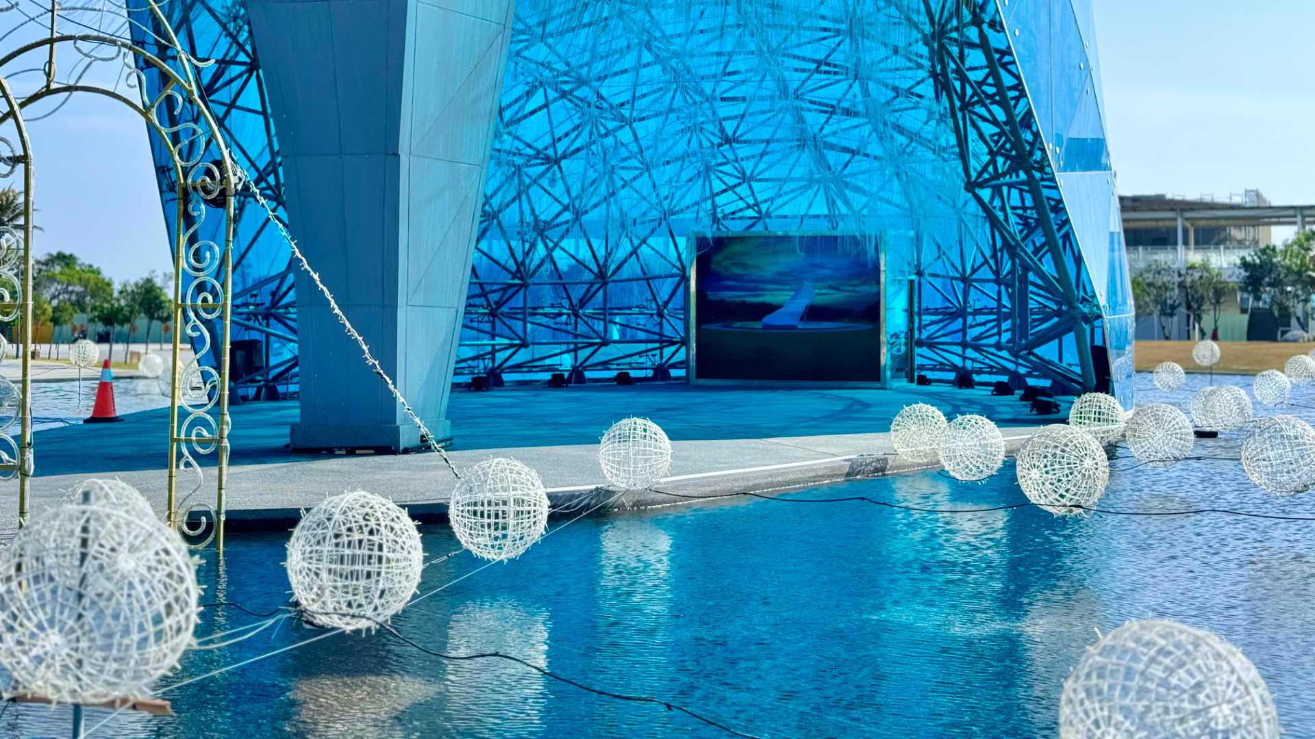 The interior of the High Heel Church –&nbsp;it’s a large space without furniture and decorations hanging from the glass ceiling. At the front of the space is a floor-to-ceiling photograph of the High Heel Church.
