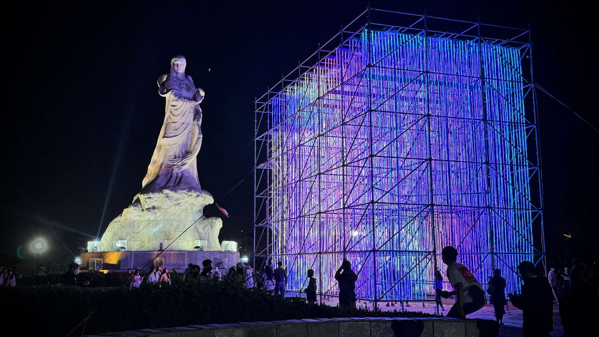 The Journey of Prosperity art installation –&nbsp;a cube-like shape comprising thousands of strands of hanging lights, with a large classical statue in the background.