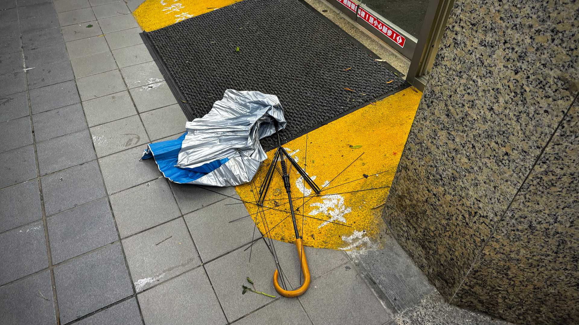 A thoroughly-destroyed umbrella abandoned on the sidewalk outside a convenience store in Kaohsiung, Taiwan, post-Typhoon Gaemi.