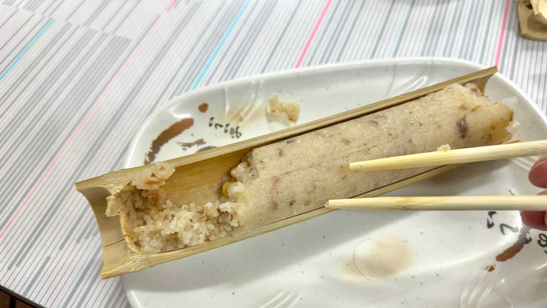 Bamboo rice, with the bamboo cracked open to show partially-eaten brown rice inside.