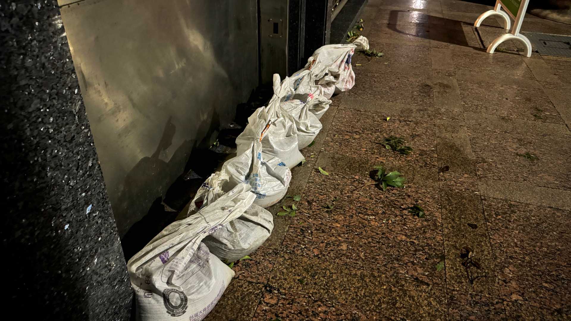 Eight sandbags blocking the entrance to a vehicle elevator for an underground parking lot.