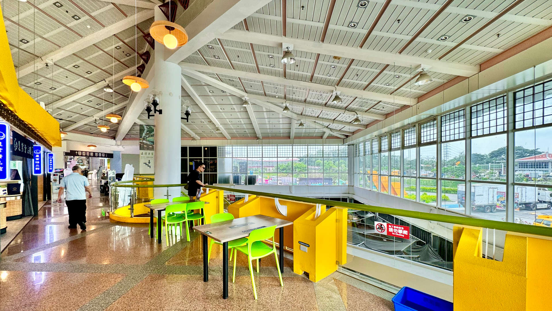 Interior of a spacious multi-level shopping mall-type space. There are only two customers visible in the space.