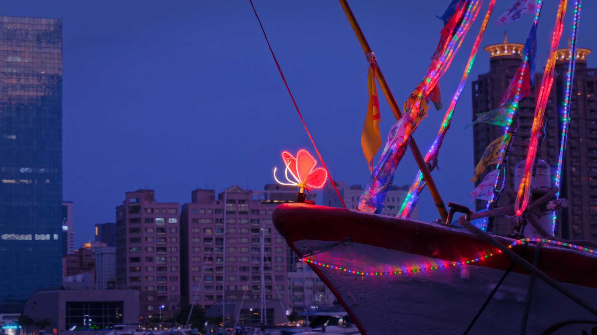An illuminated LED butterfly sculpture affixed to the front part of a Taiwanese fishing boat.