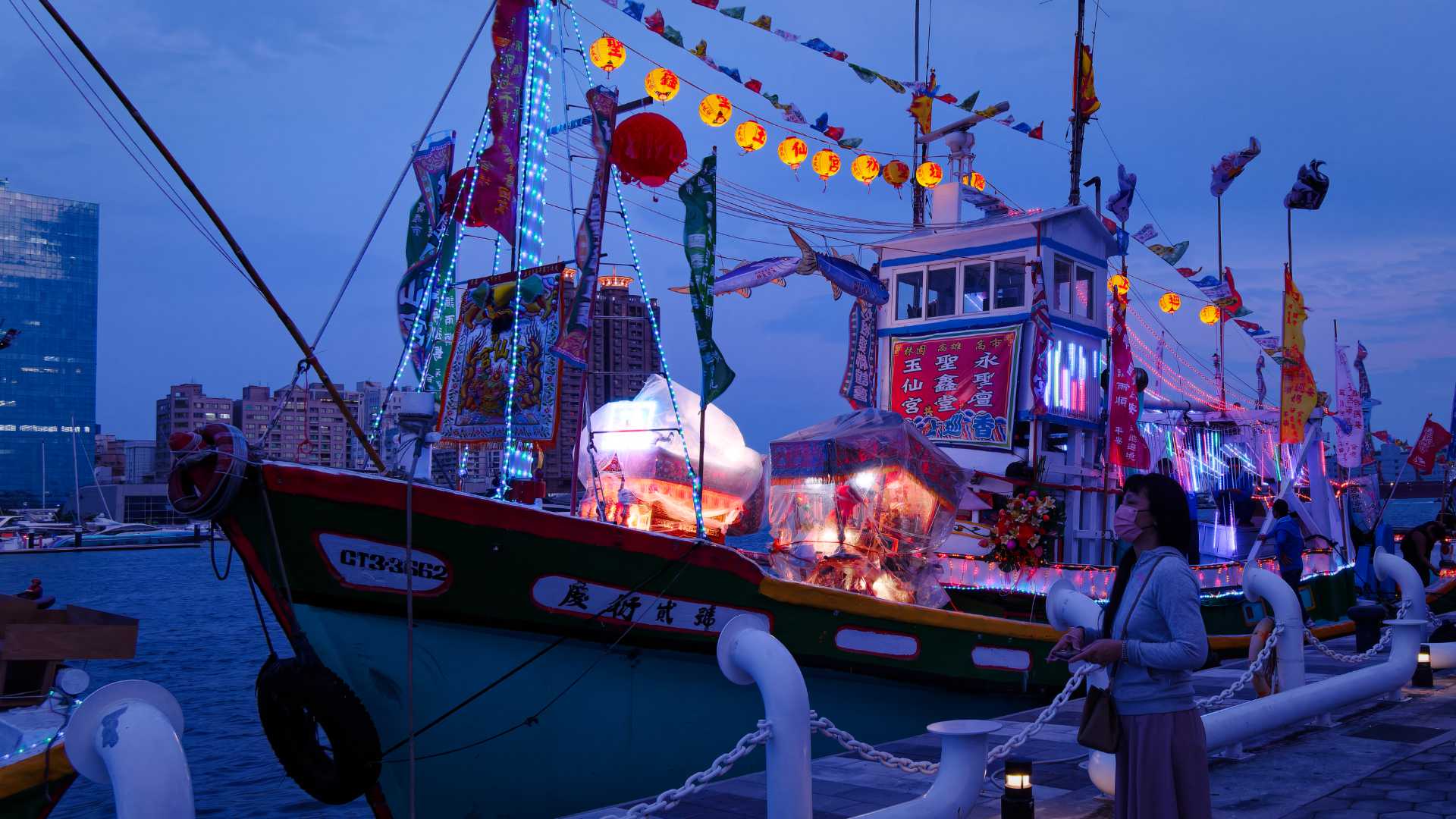 Deity boxes wrapped in protective transparent plastic sheeting, on the deck of a fishing boat.