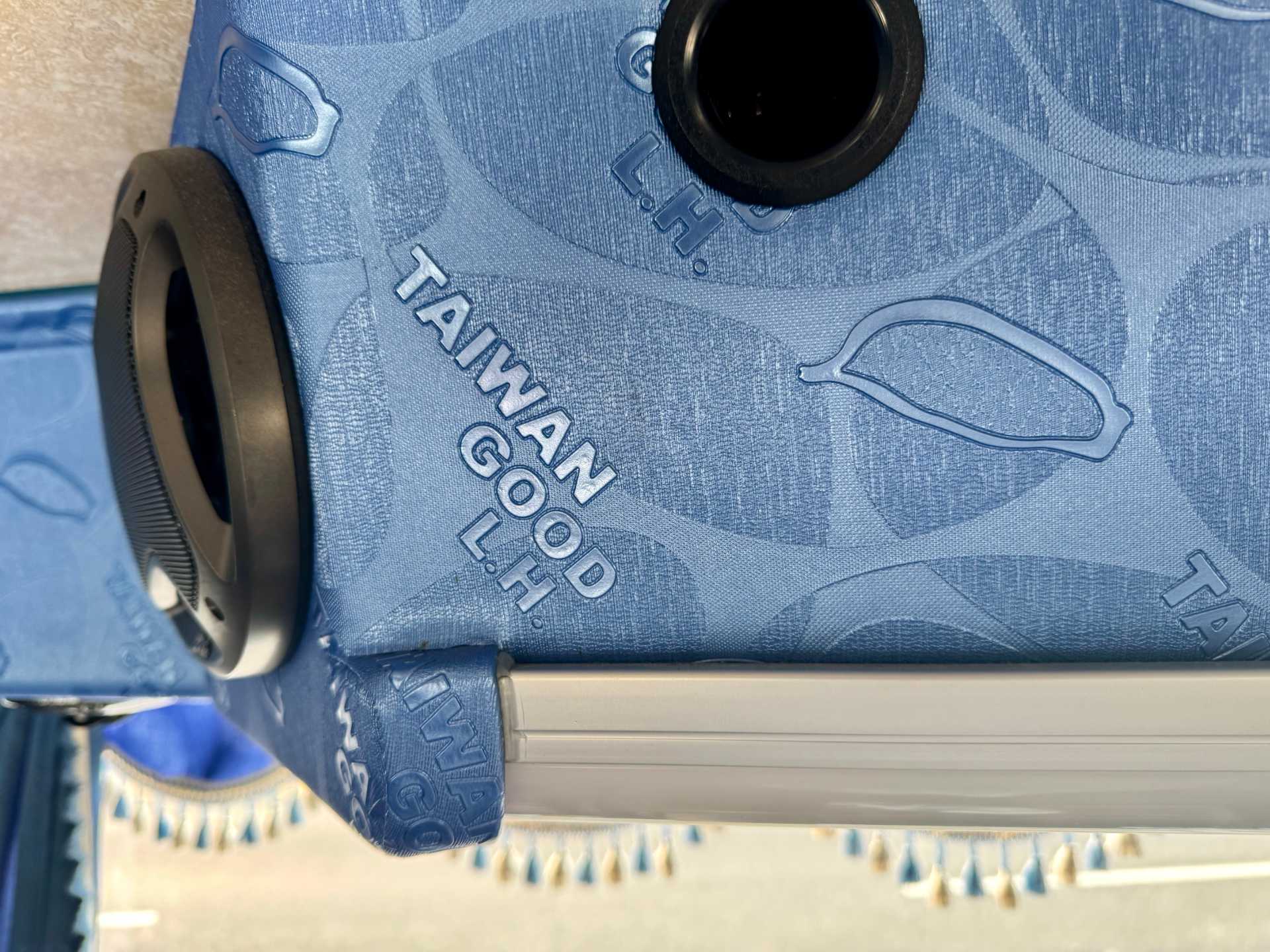 Deep blue embossed padding around the speakers on a Taiwanese tour bus. The embossed patterns include a map of Taiwan and the words ‘TAIWAN GOOD L.H.’