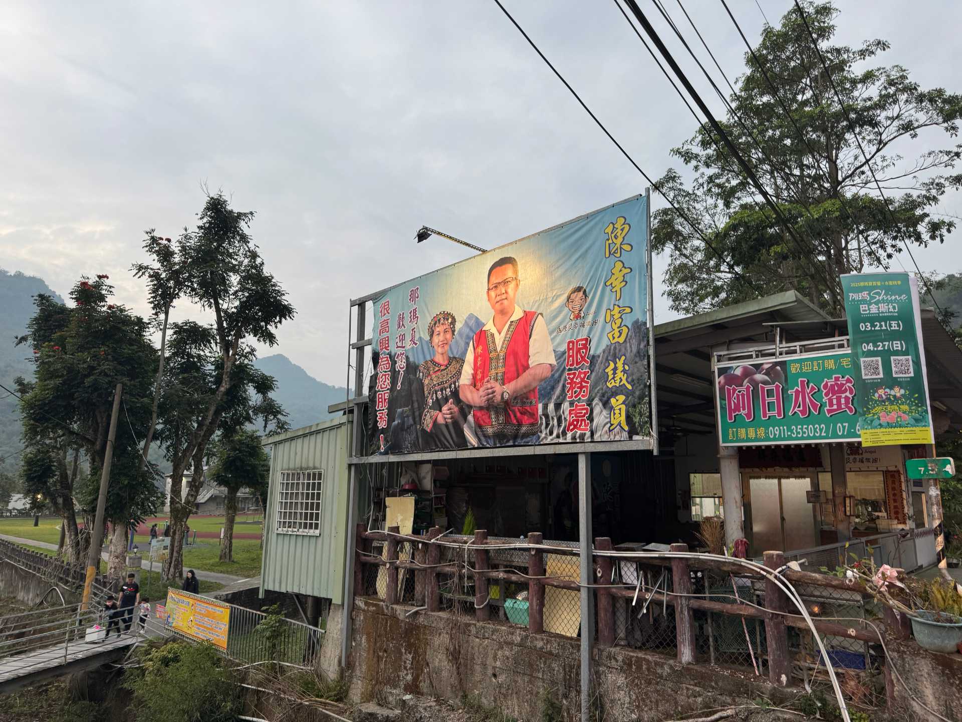 A political billboard featuring a man and woman wearing traditional indigenous Taiwanese clothing.