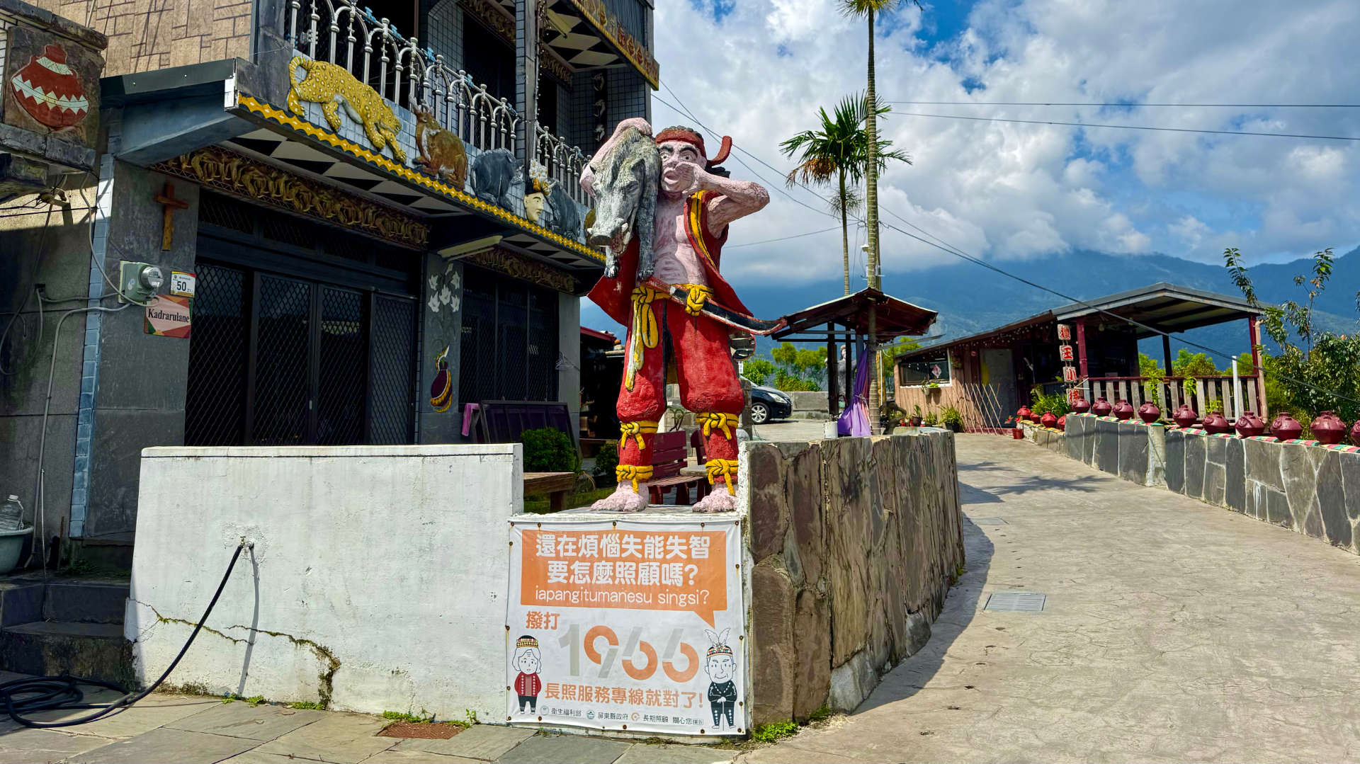 Colorfully-painted statue of a man carrying a wild boar on his shoulder, in Wutai Township, Taiwan.