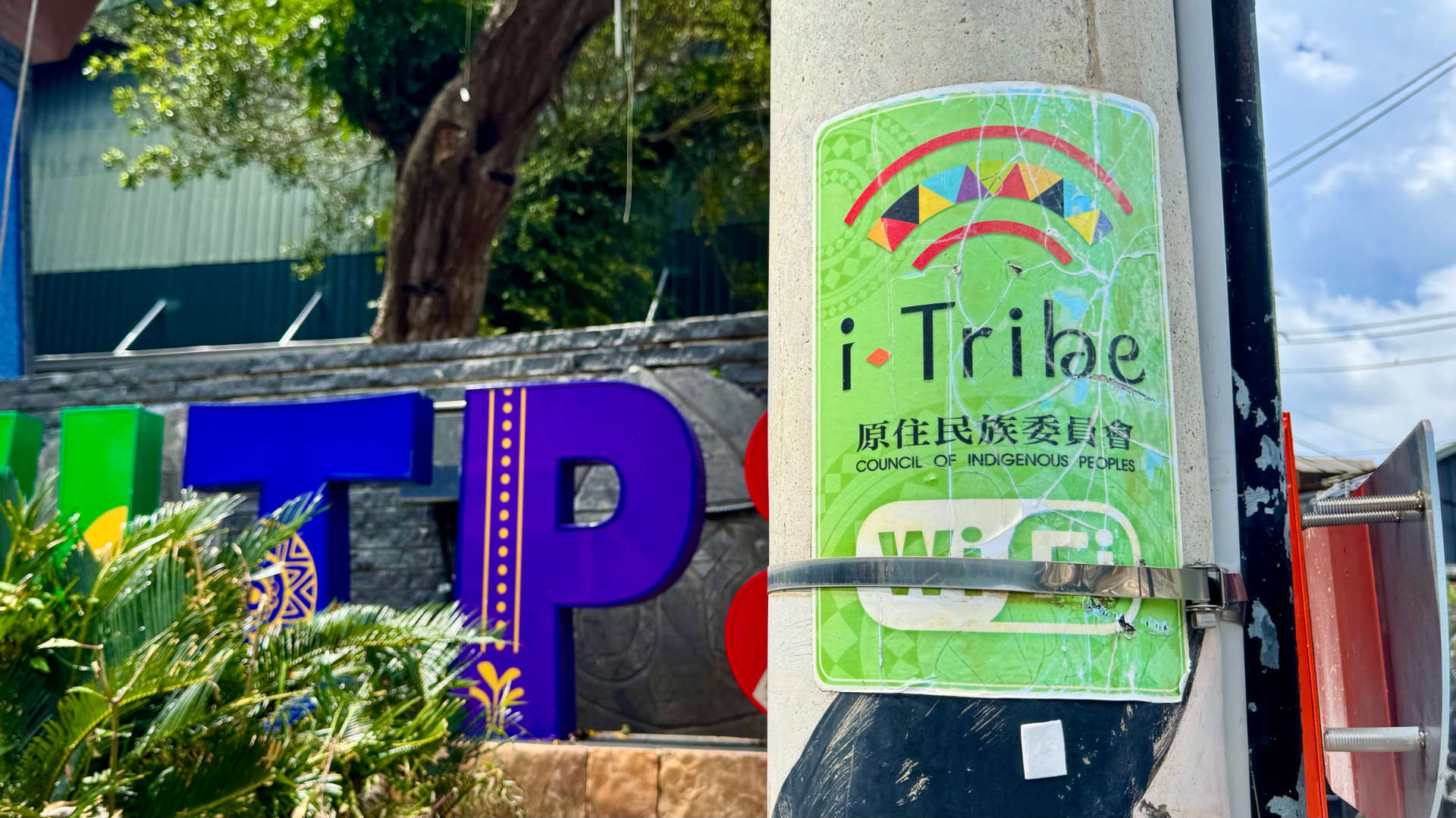 A colorful poster affixed to a lamppost, advertising the i-Tribe free Wi-Fi service.