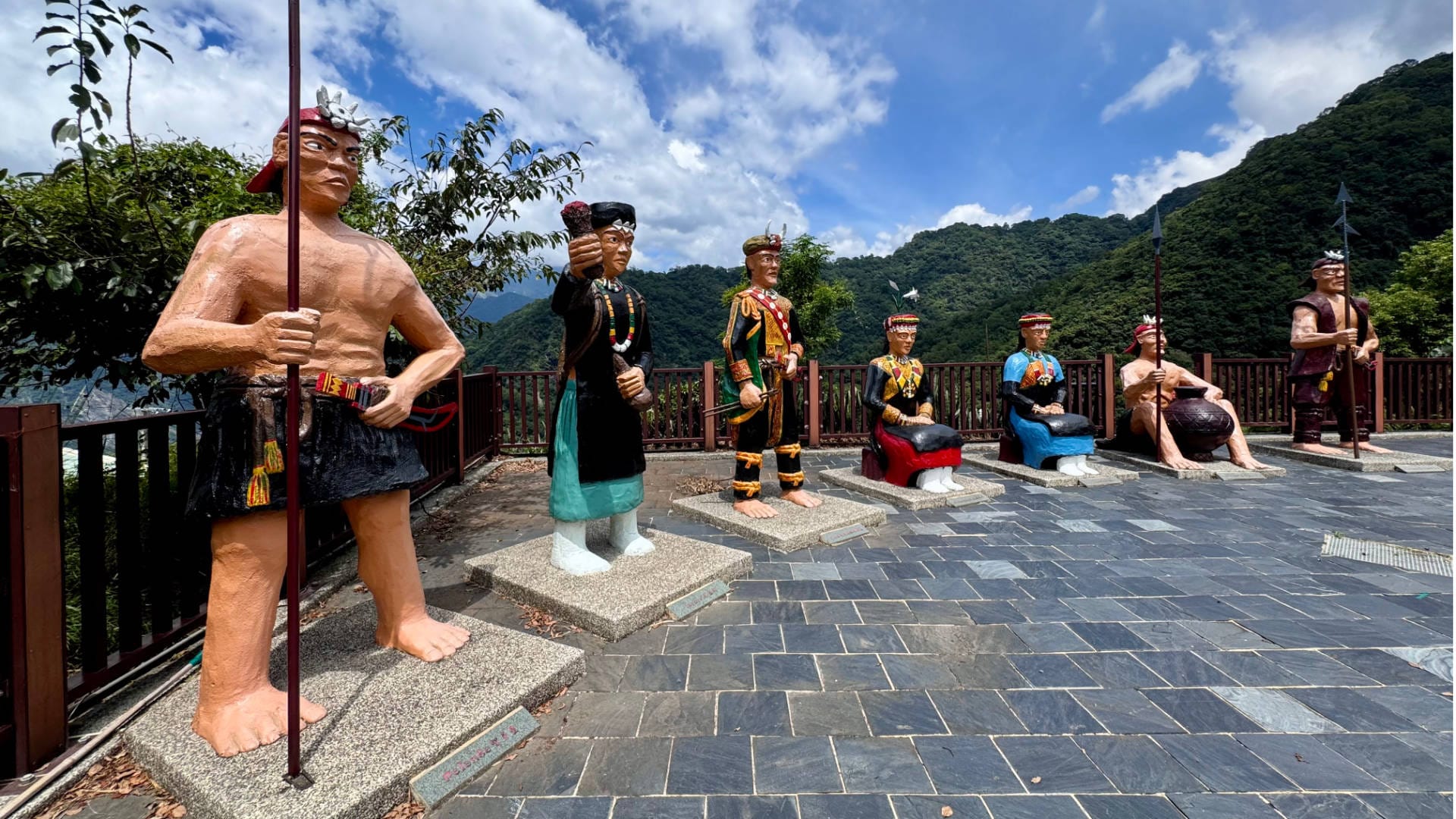 Seven large Rukai statues depicting people in traditional indigenous attire.