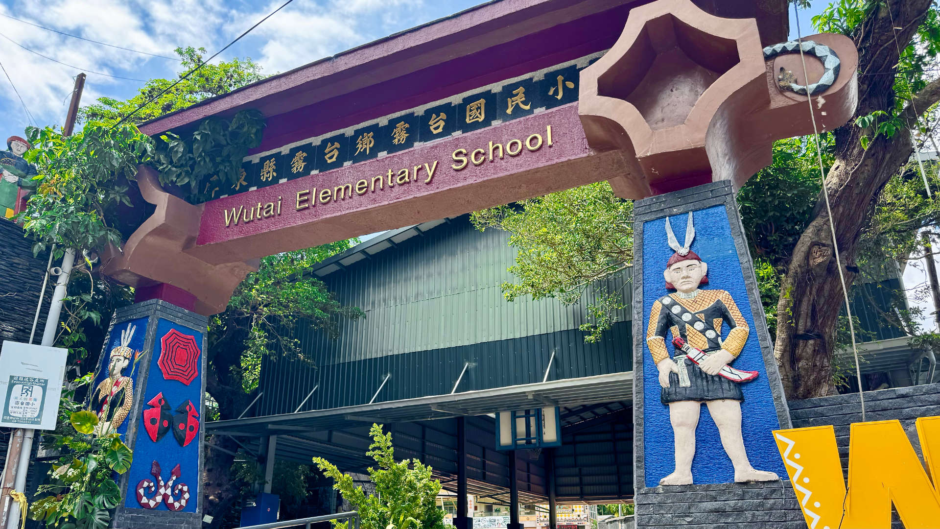 A gate at the entrance to Wutai Elementary School. The pillars of the gate are decorated with brightly-painted characters in indigenous attire.