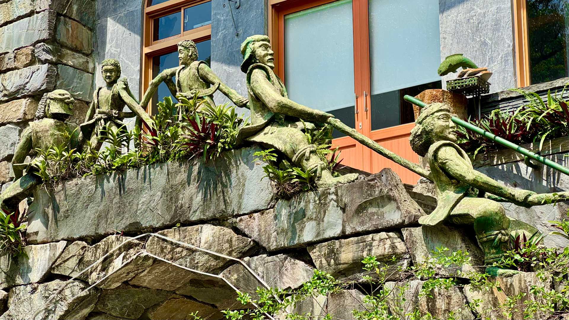 Close-up of statues of indigenous people holding the balustrades of the Wutai Presbyterian Church.