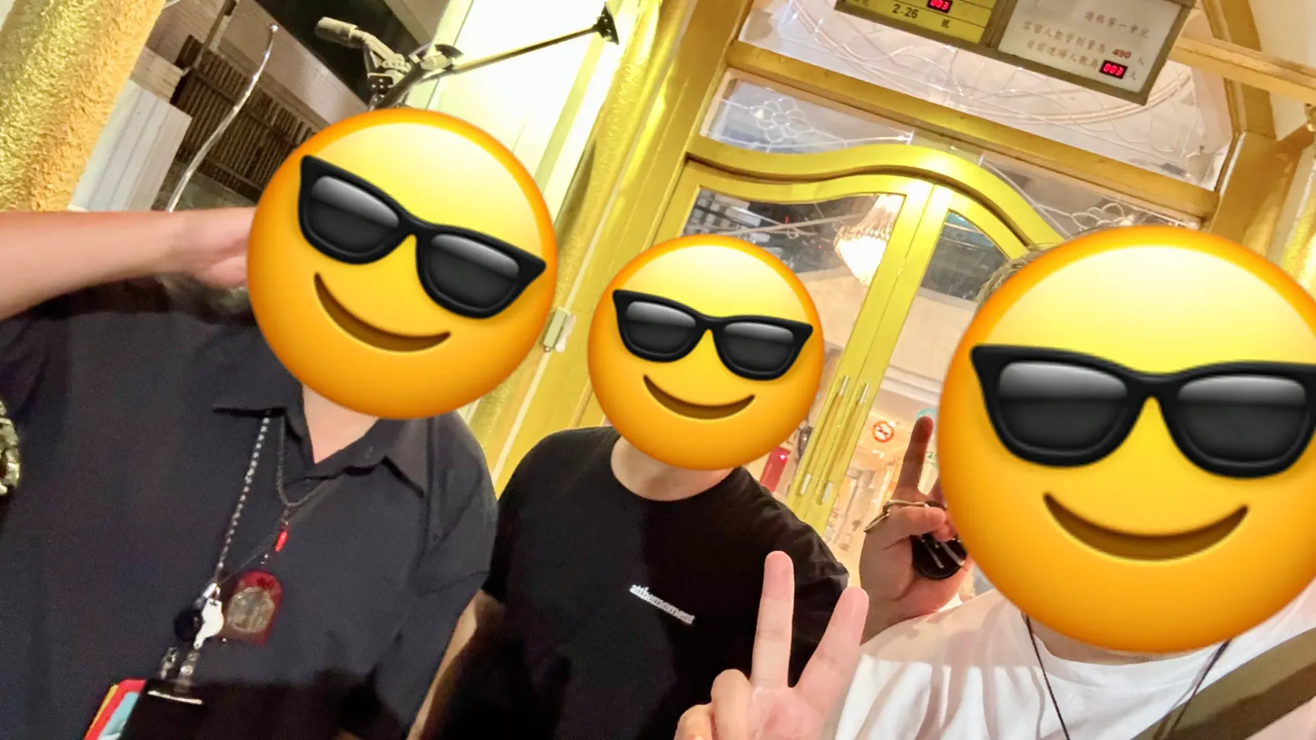 Three happy men standing outside Soaring Spirit KTV in northern Kaohsiung, Taiwan.