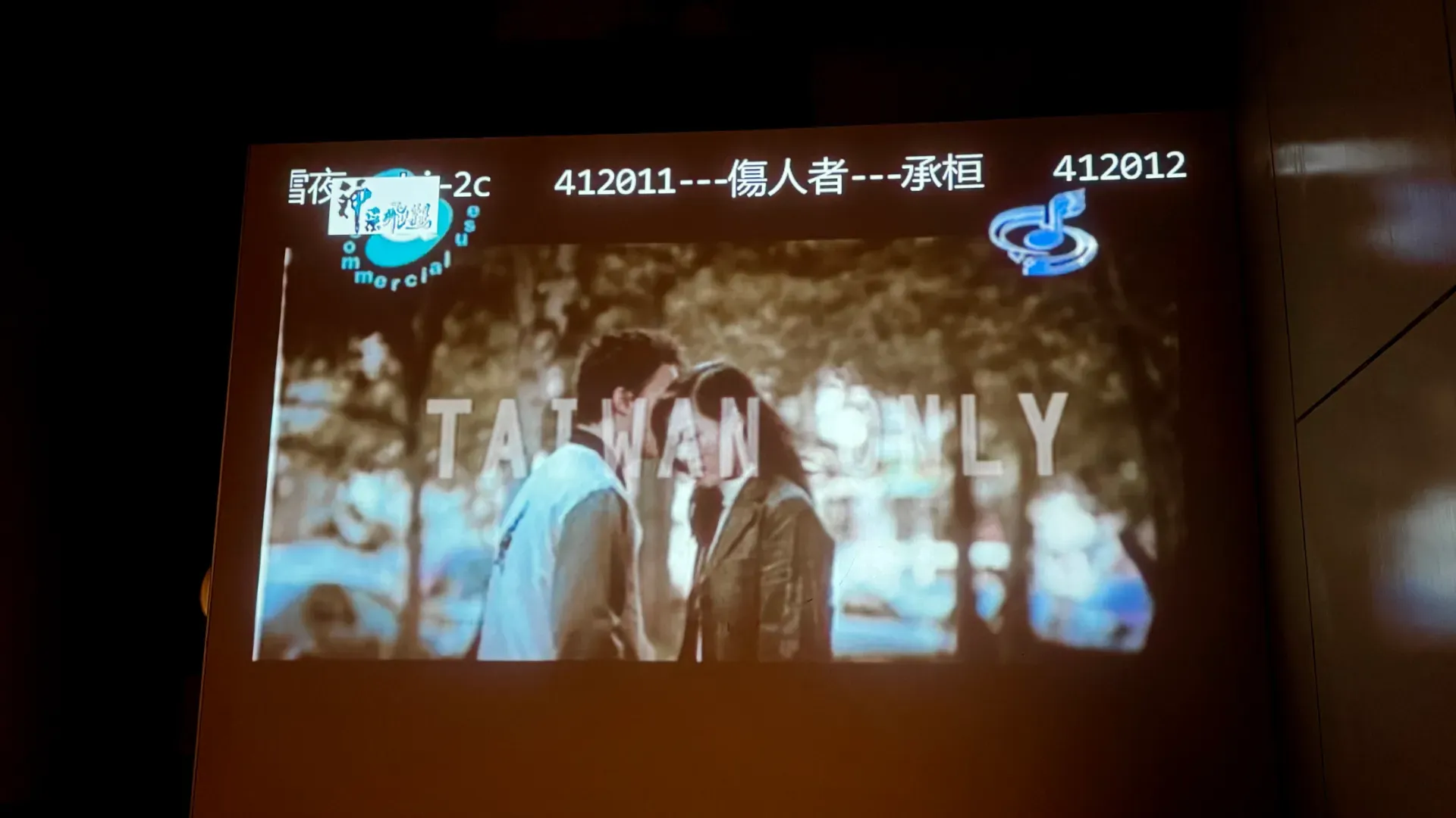 A music video being projected onto a wall in a private KTV room, with ‘TAIWAN ONLY’ superimposed on the screen.