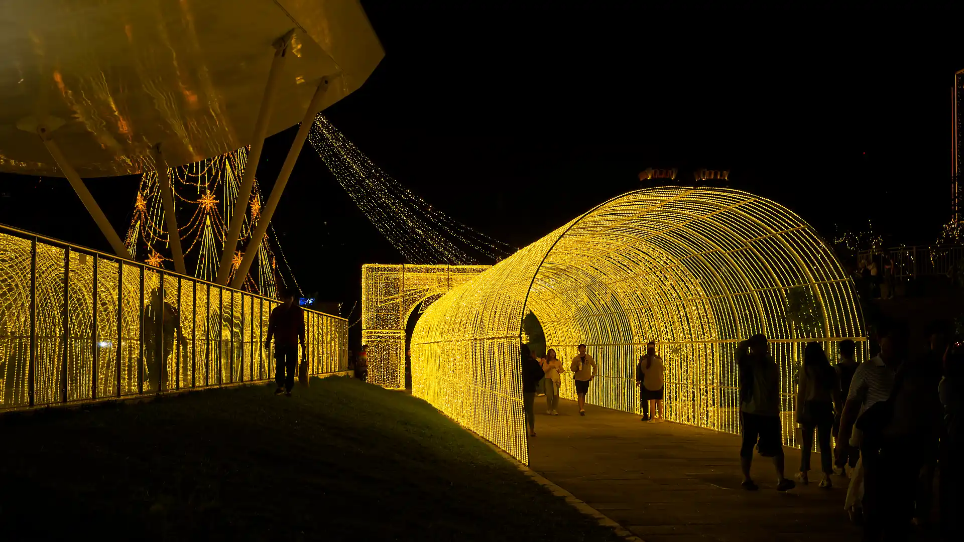 A dozen people walking though a light tunnel installation.