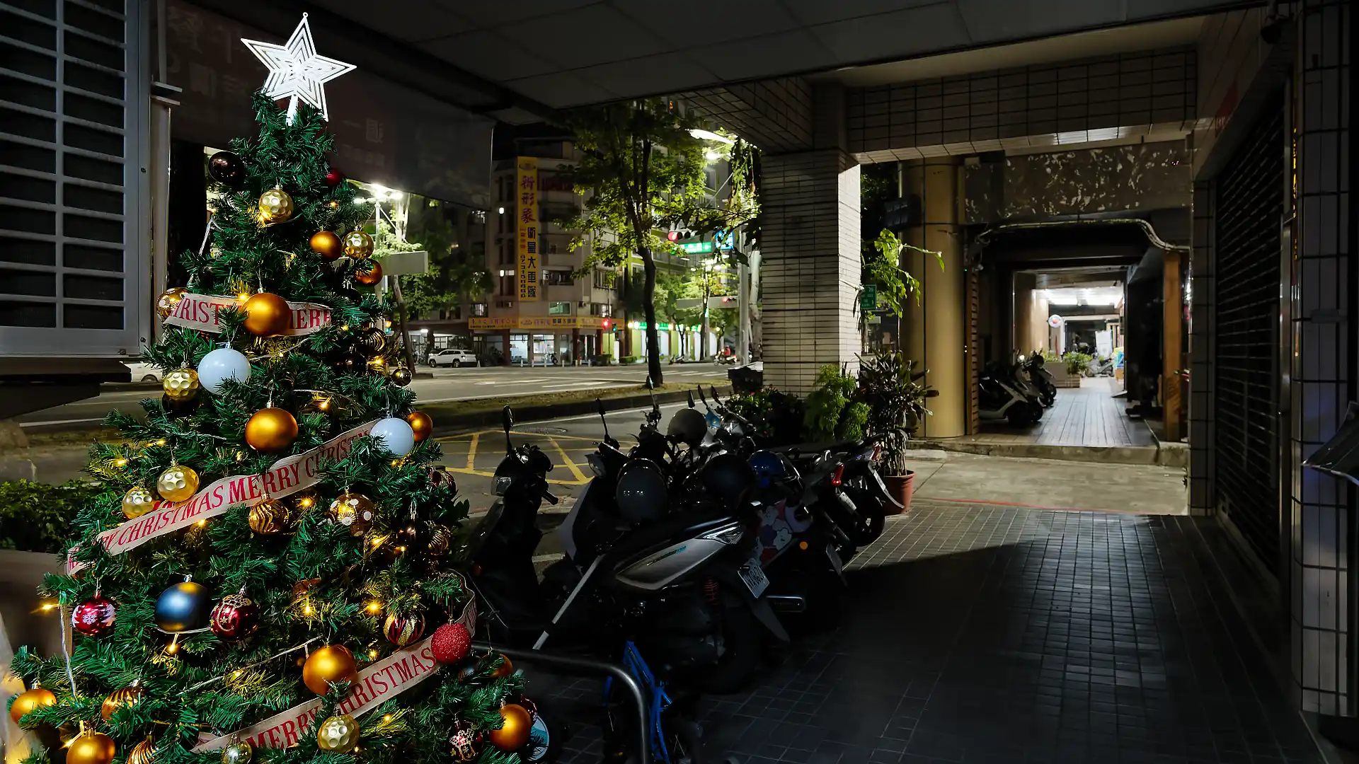 A tastefully-decorated artificial Christmas tree, approximately two meters tall, on a sidewalk in Lingya District, Kaohsiung, Taiwan.