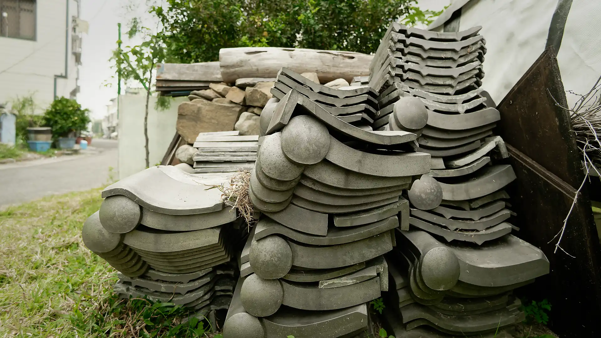A stacked pile of Japanese-style roof tiles, on a grass lawn.