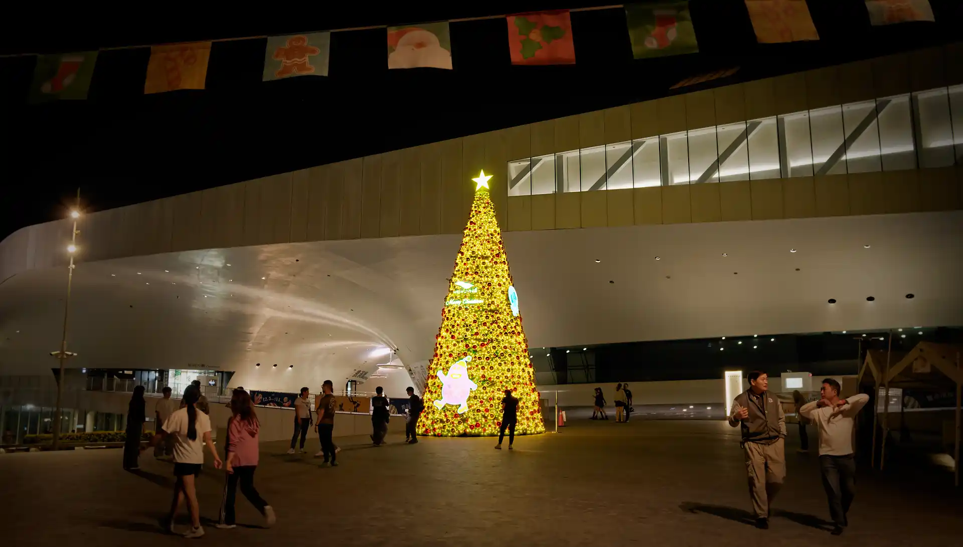 A large yellow and red Christmas tree, topped with a star, outside the Weiwuying National Kaoshiung Center for the Arts.