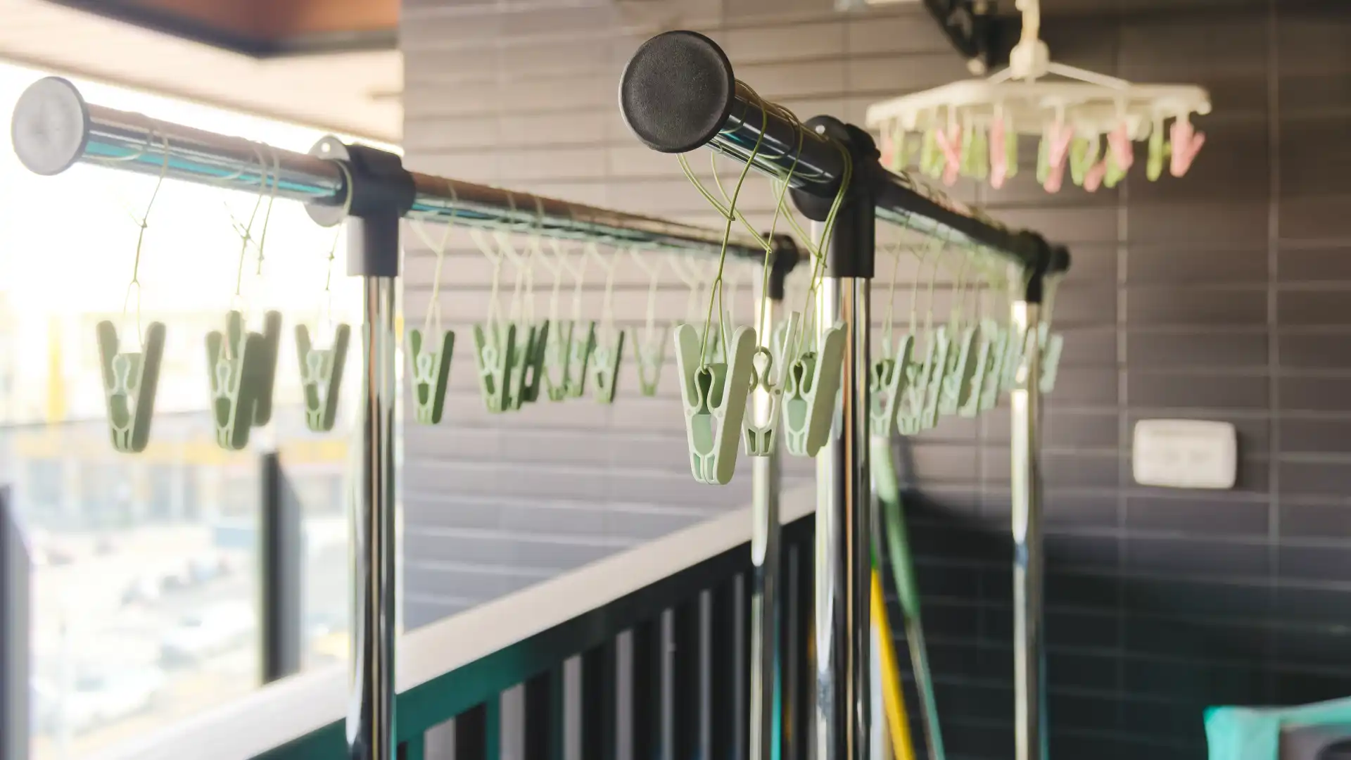 A tall metal laundry rack on a Taiwanese balcony. It comprises two main horizontal rods with hanging pegs.
