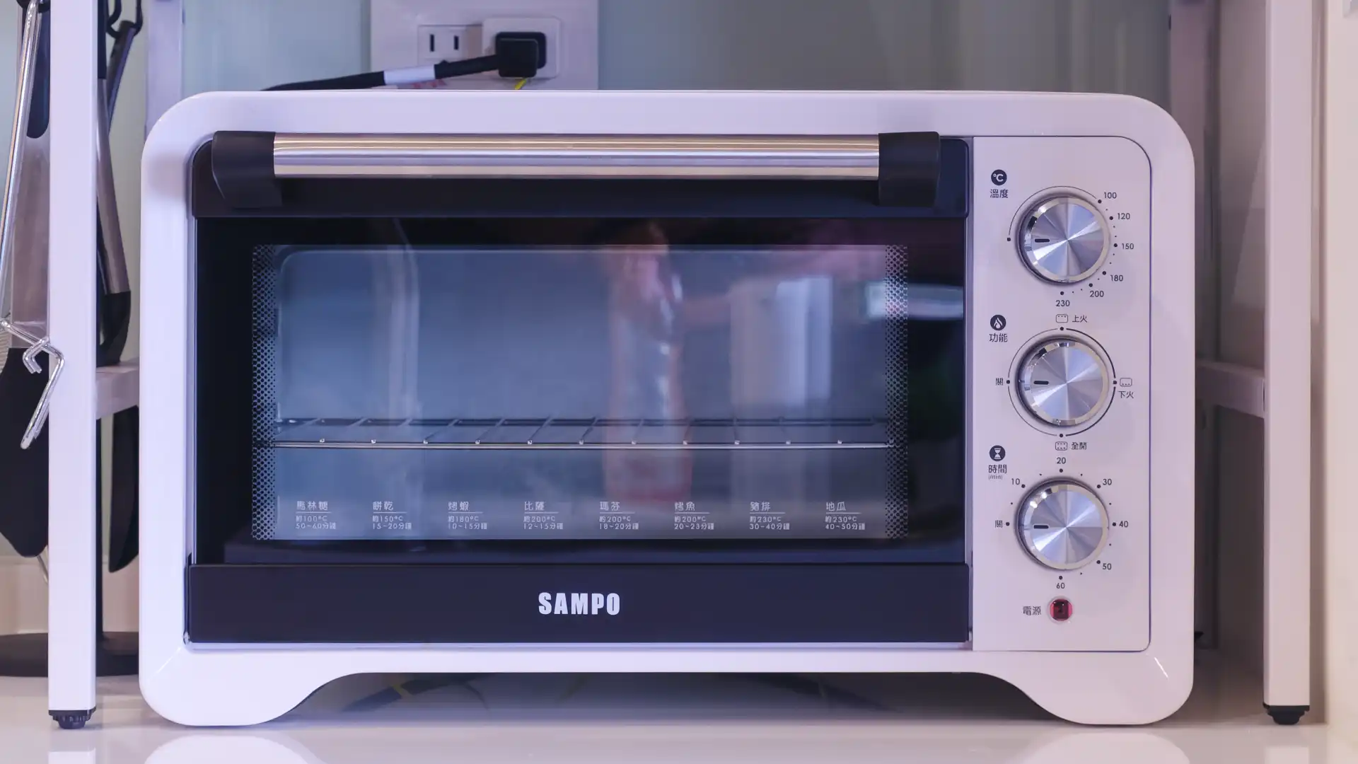A medium-sized benchtop oven made by Sampo. It has dials for temperature, heating mode, and timer.
