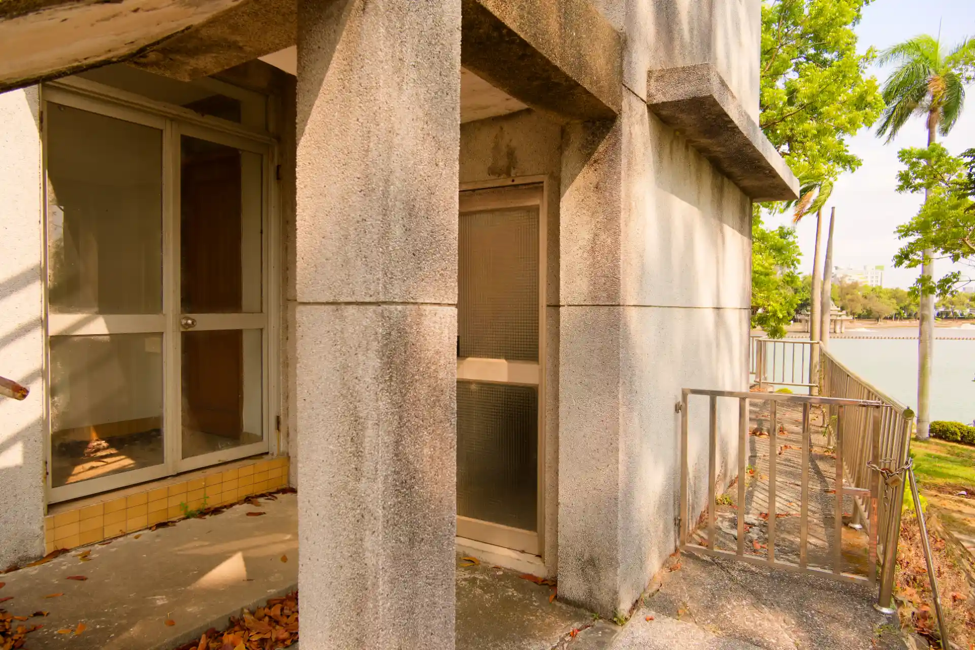 Two glass side doors, one frosted and one transparent, seen from outside a building. A large lake is visible in the distance.