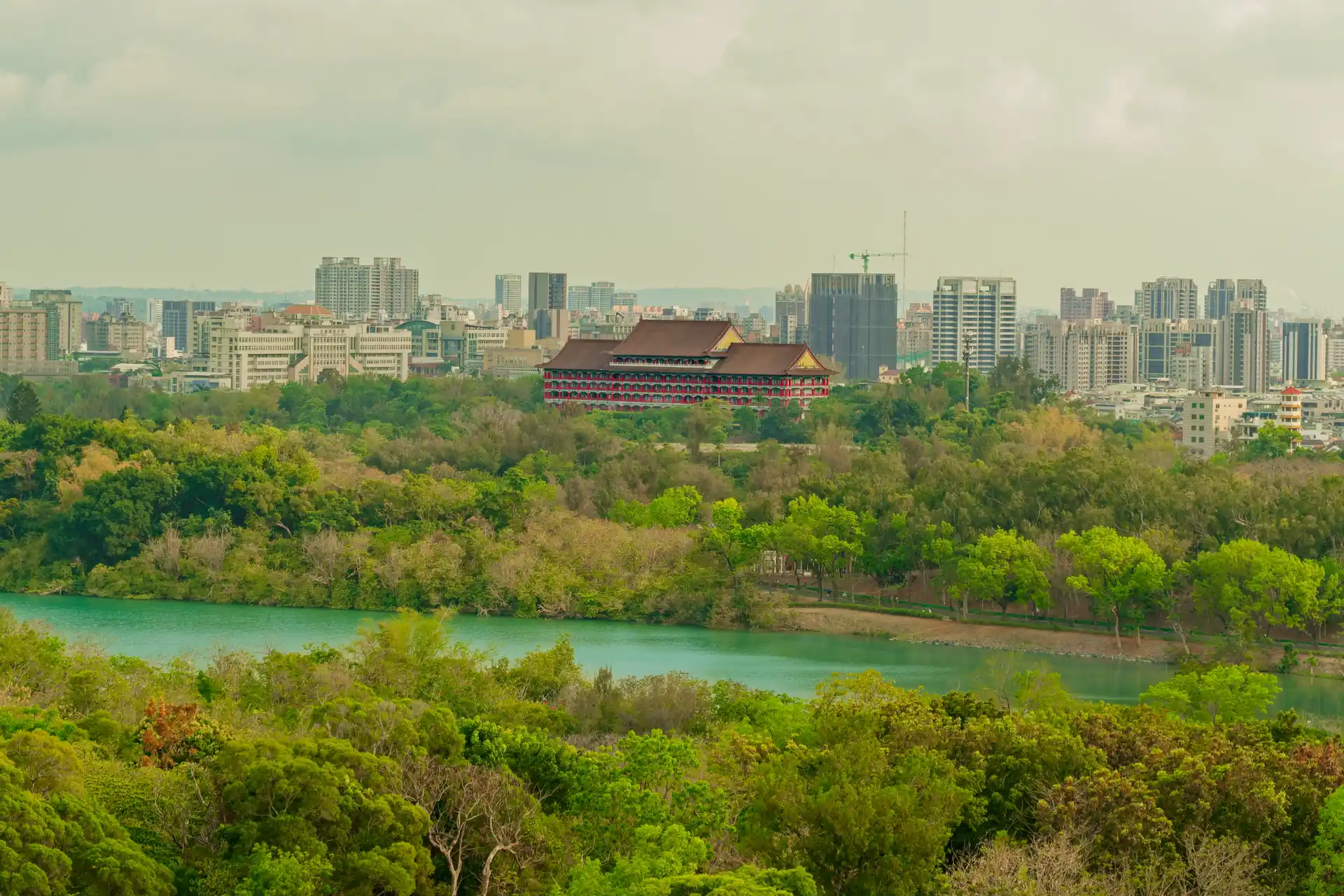 The Kaohsiung Grand Hotel visible across Chengcing Lake, with mid- and high-rise apartment buildings in the distance.