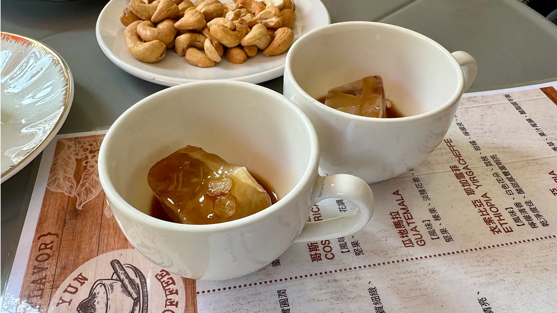 Close-up of some rich-looking coffee poured over a large ice cube in a coffee cup.