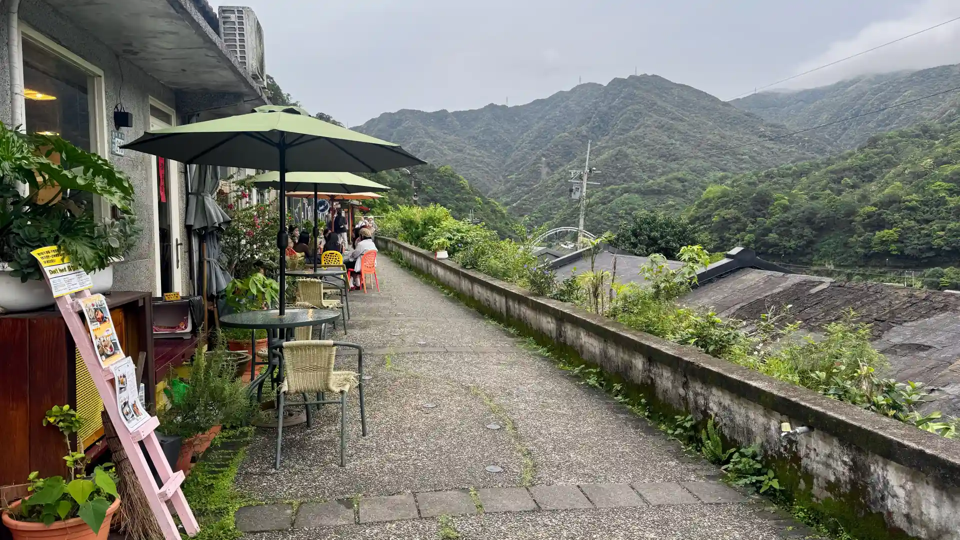 A line of cafes on a paved terrace above Houtong Cat Village.
