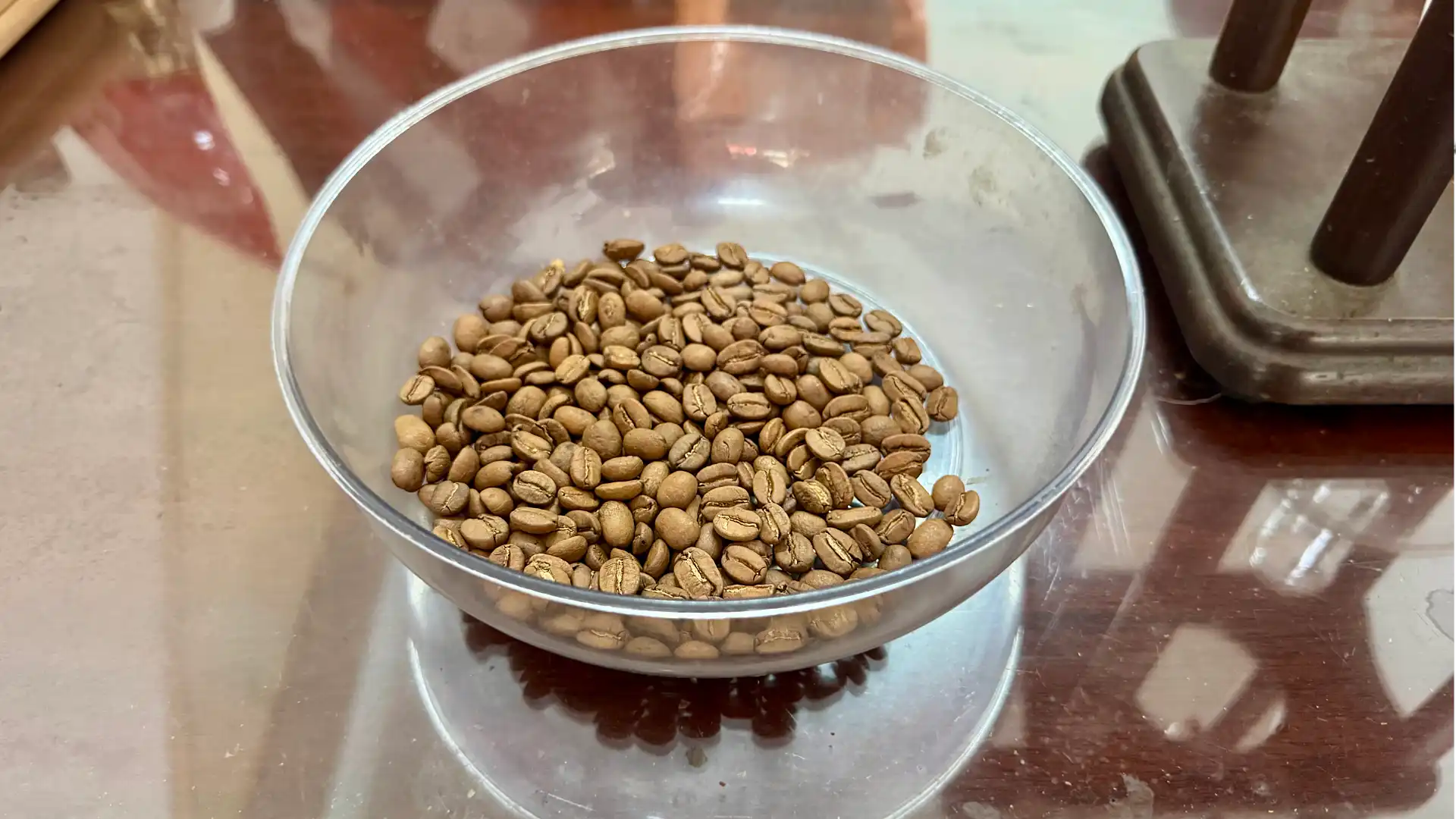 A glass bowl of roasted coffee beans.