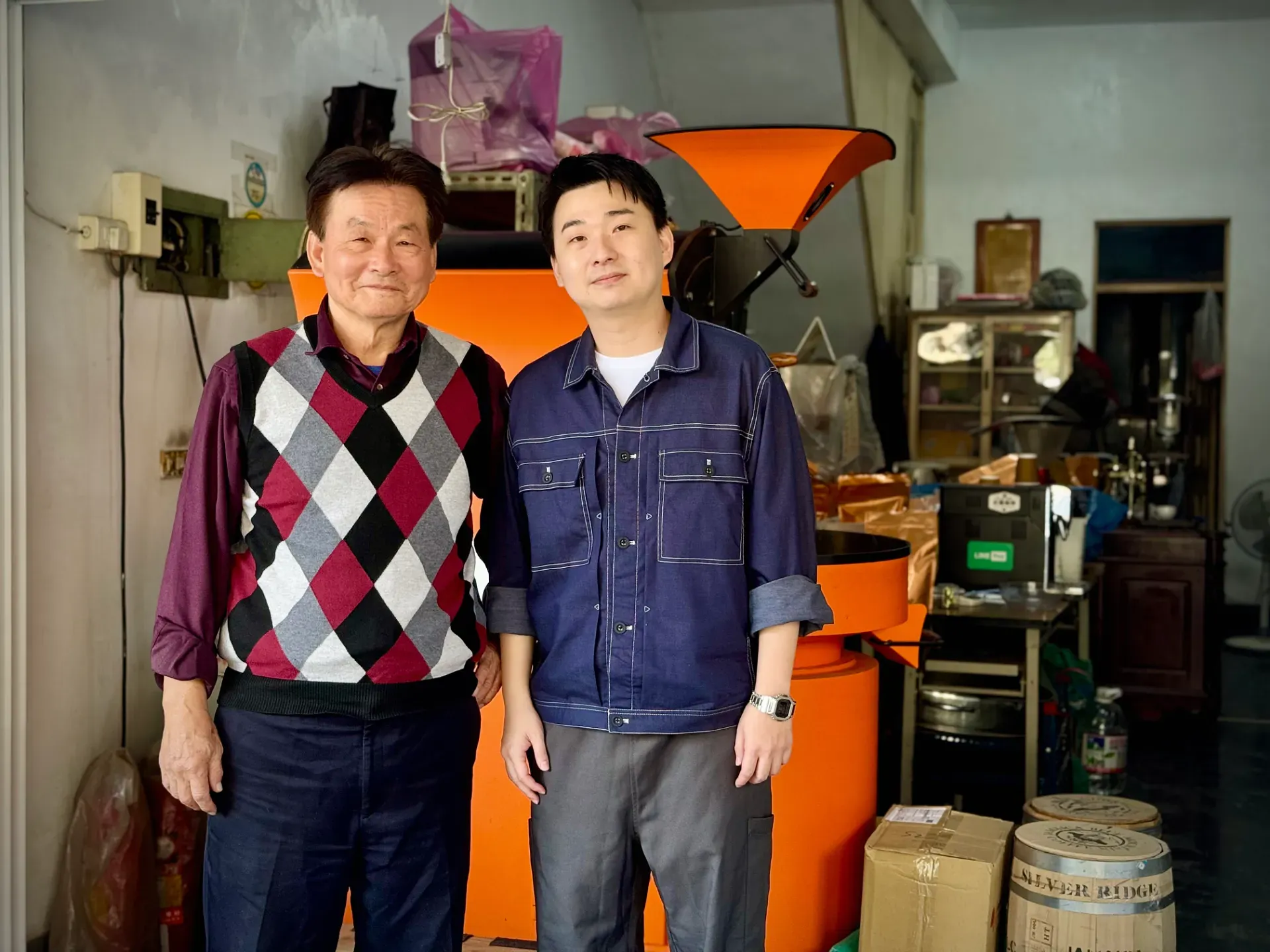 Master Li and his son Teddy, standing at the entrance to Hou Yun Coffee in Kaohsiung, Taiwan.