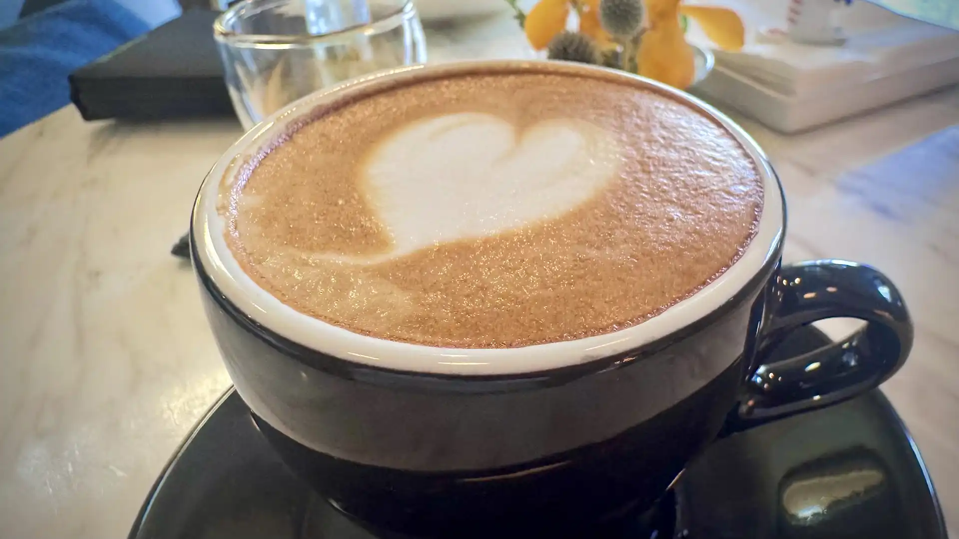Close-up of a hot cappuccino, with heart-shaped foam art.
