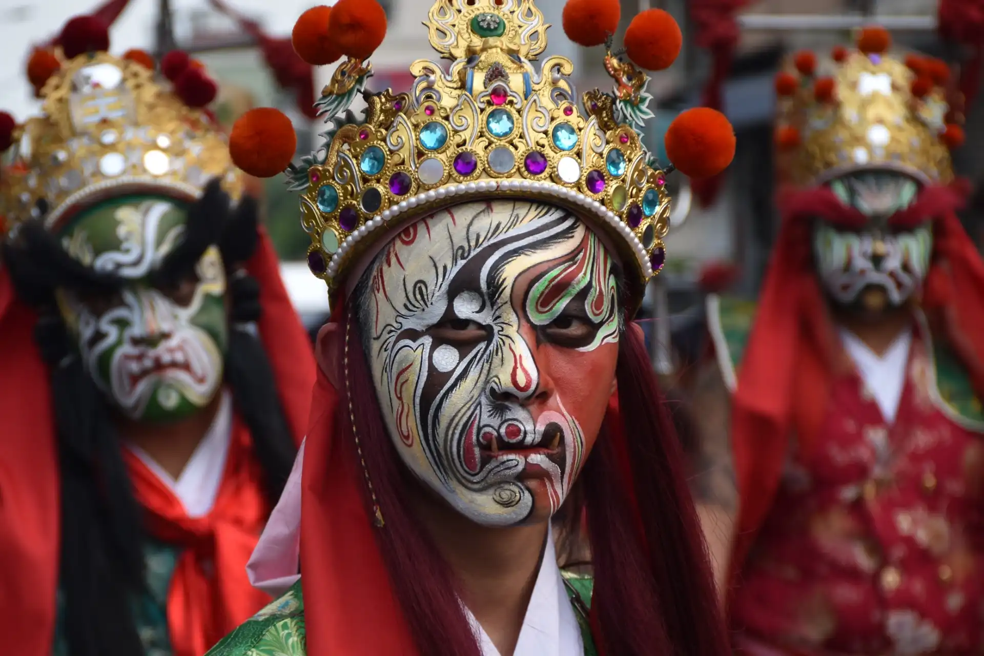 Close-up of an Eight Generals performer wearing elaborate face paint and looking directly at the camera.