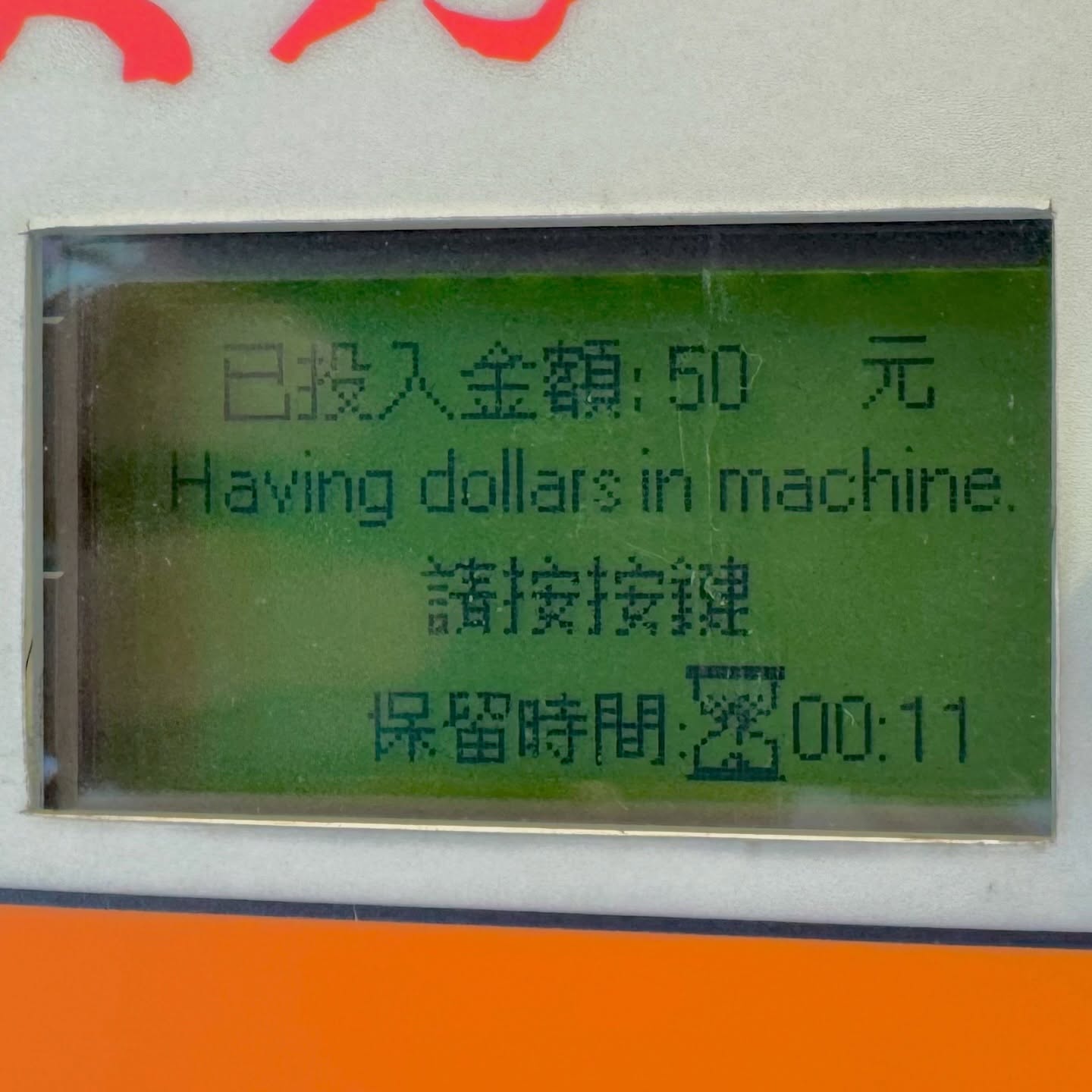 Close-up of a dot matrix display on a Taiwanese parking machine, which includes the English sentence “Having dollars in machine.”