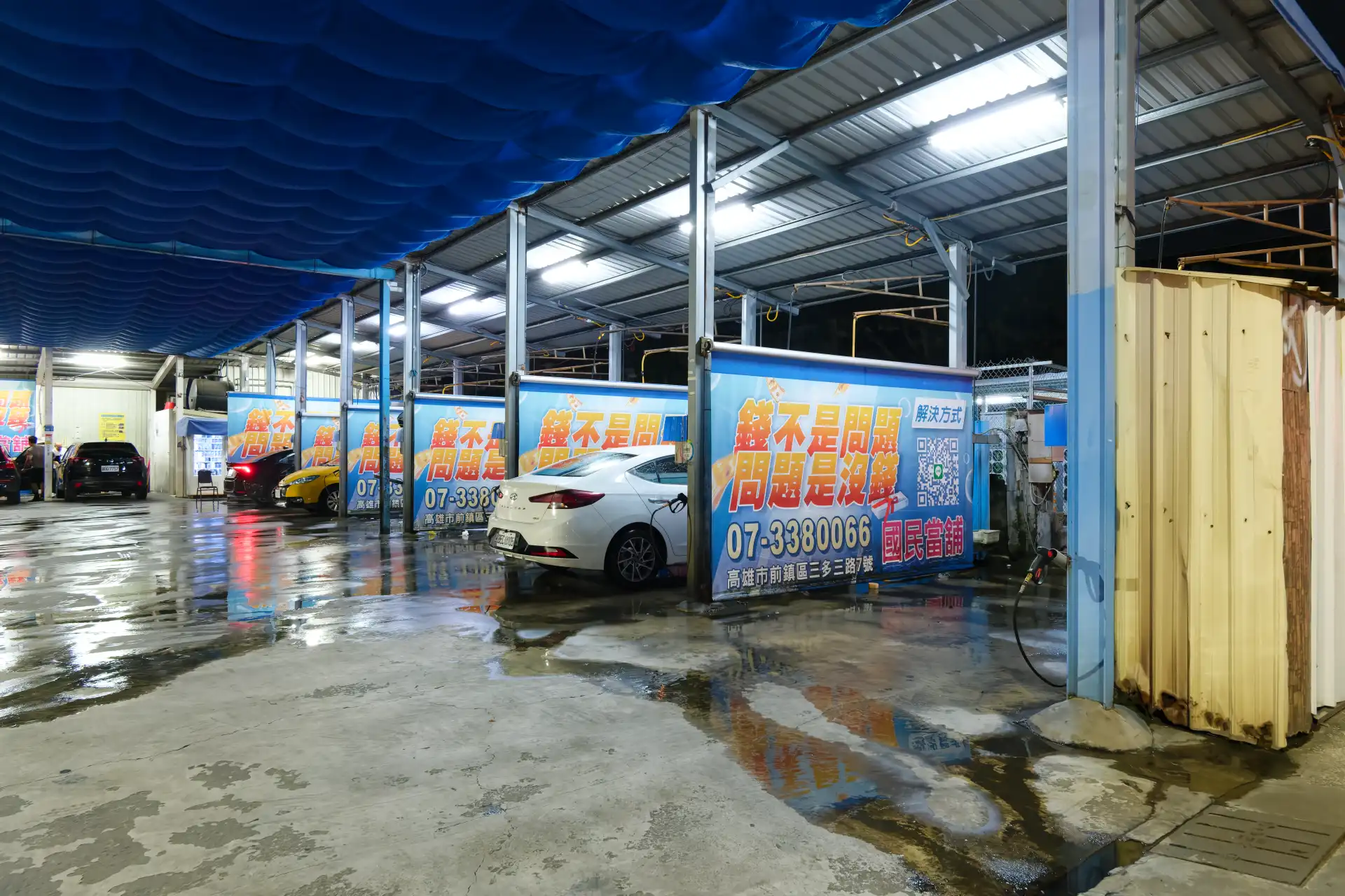 Cleaning booths at a self-service carwash at night.