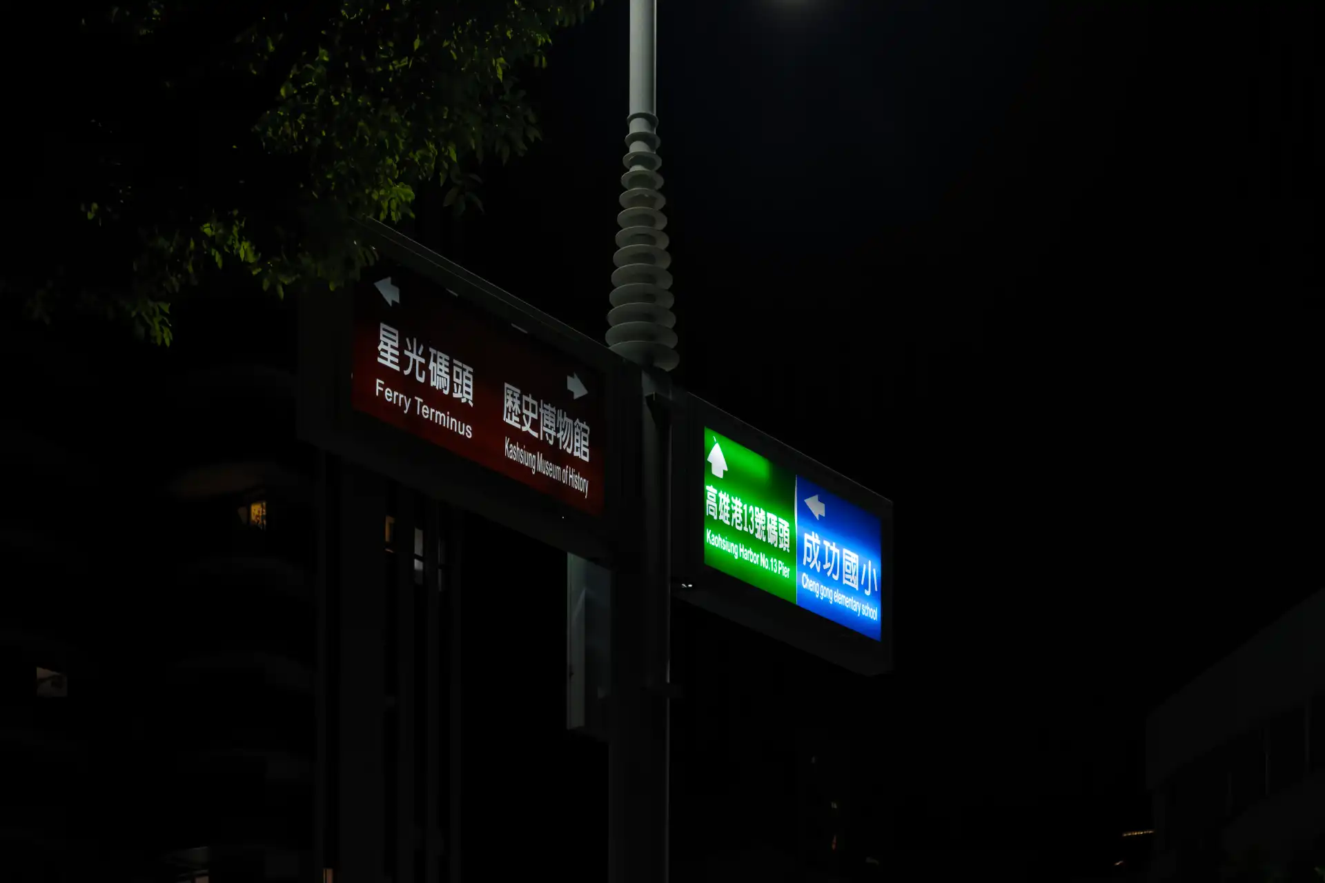 A retro-futuristic / space-age modernist road sign with illuminated directions for a ferry terminus, a museum, a pier, and an elementary school.