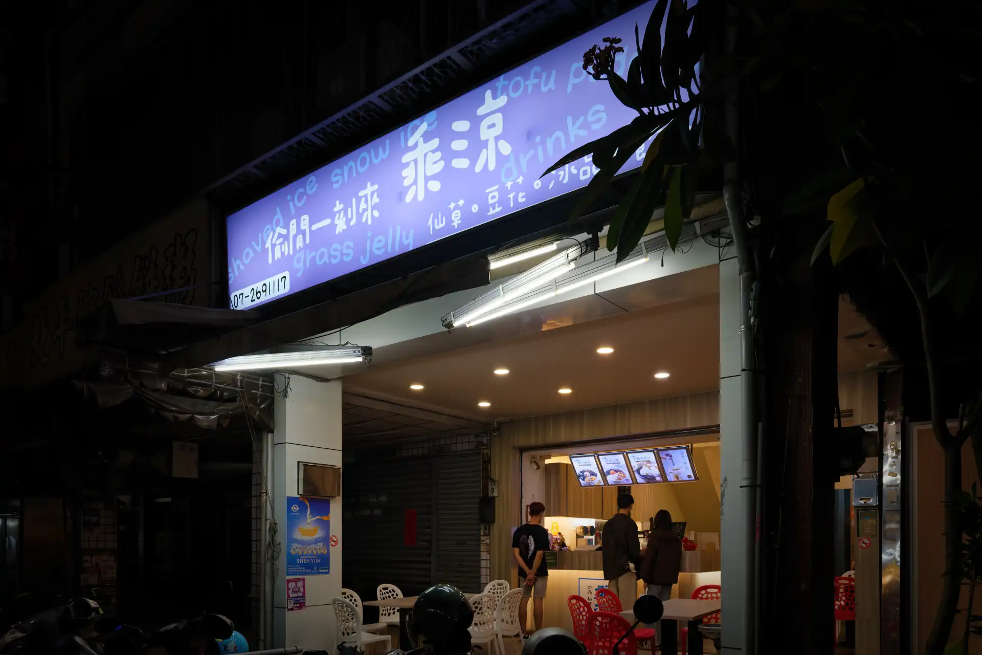 People queueing at a Taiwanese dessert shop at night.