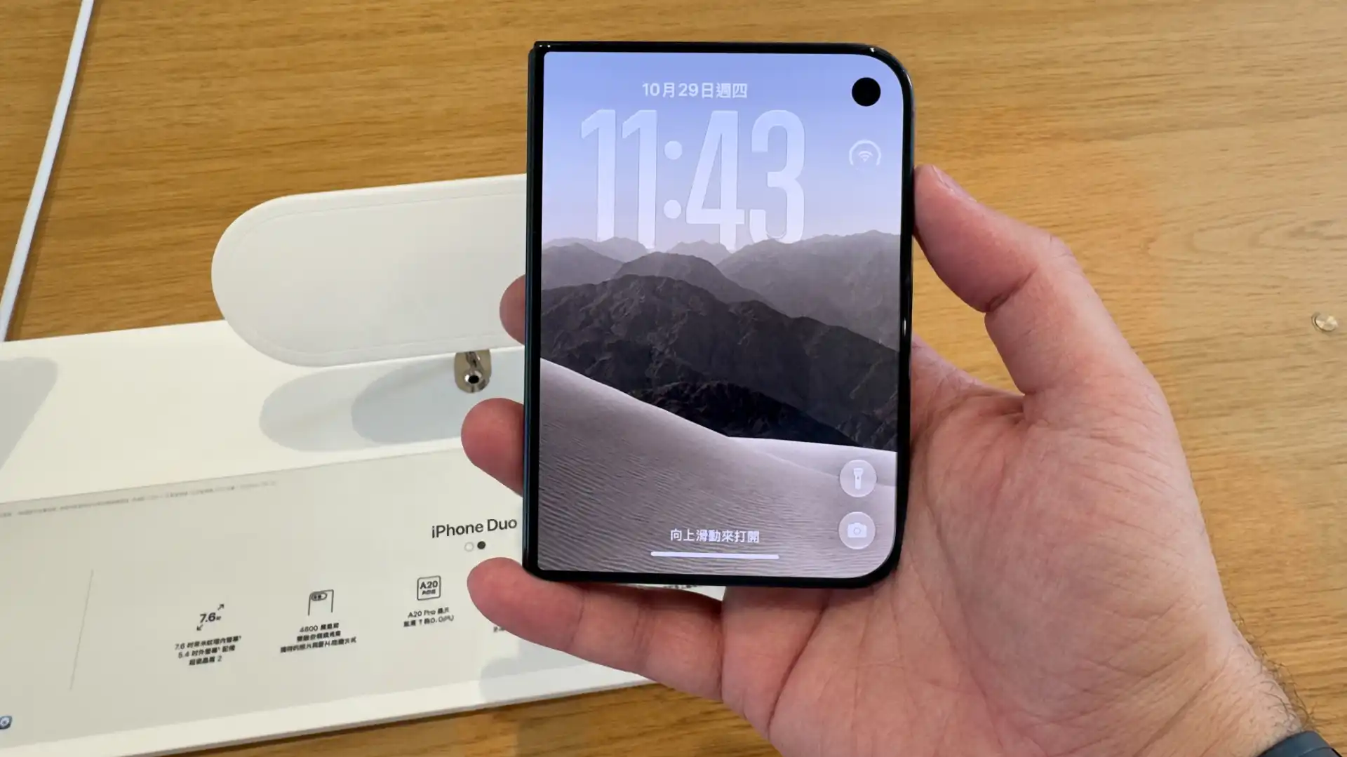 A man’s hand, holding an iPhone Duo in its closed position.