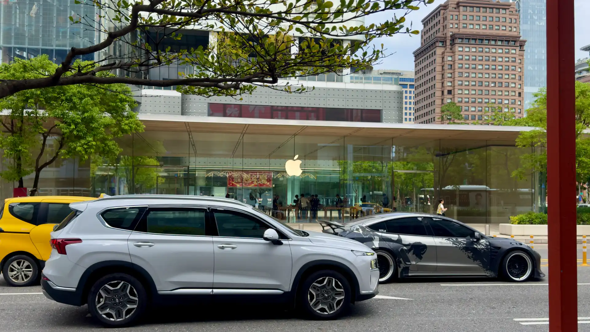 The Xinyi Apple Store in Taipei, Taiwan, viewed from across a busy street.