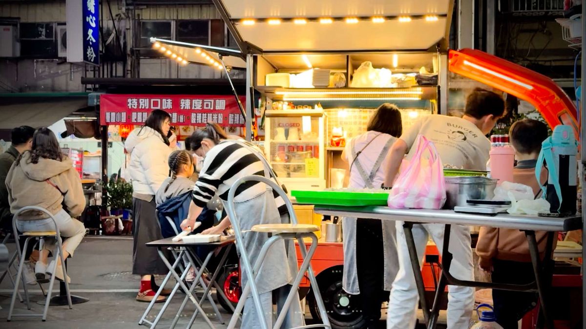 Customers gathered around a dumpling food cart on a street in Taiwan.