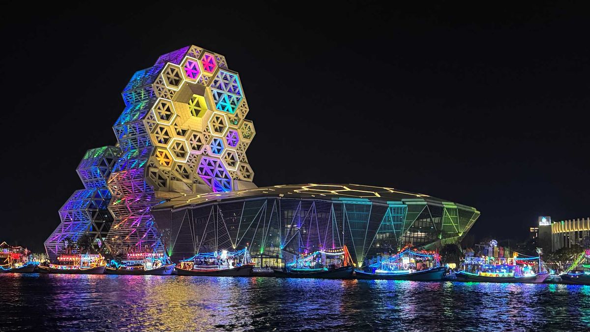 Colorfully-illuminated fishing boats docked next to the Kaohsiung Music Center during the Mazu Sea Patrol Rite.