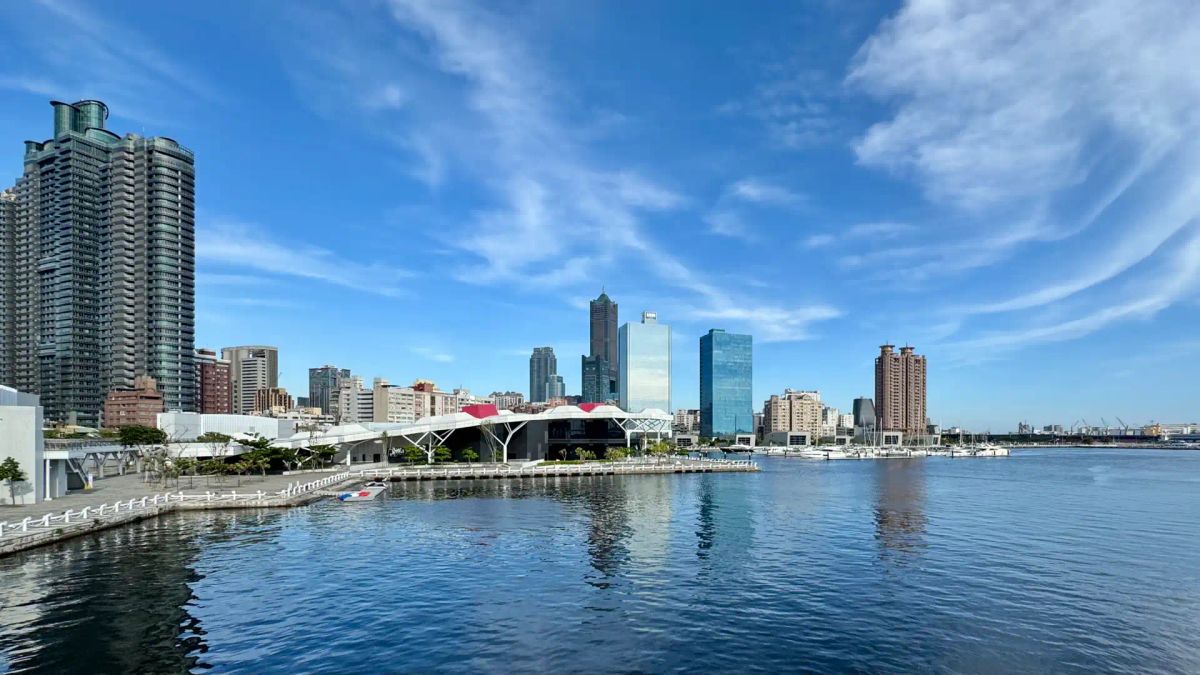 Wide-angle view of the Kaohsiung Harbor at Glory Pier on a sunny day, with the skyscrapers of Lingya District visible beyond.