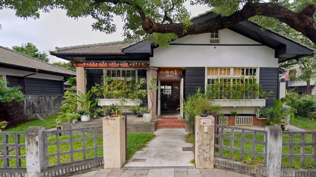 Google Maps street view screenshot of a restaurant in a historic wooden house set in a neat leafy garden.