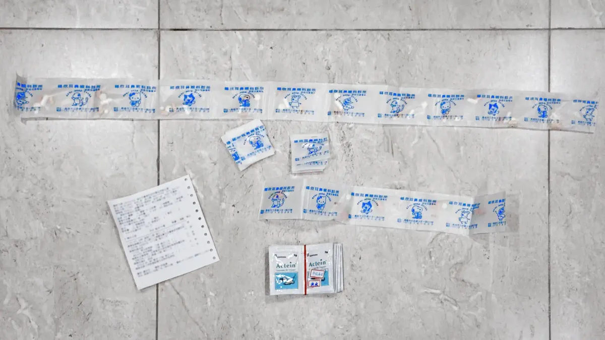 A strip of Taiwanese medicine packs decorated with cartoons, each containing half a dozen tablets for a single dose.