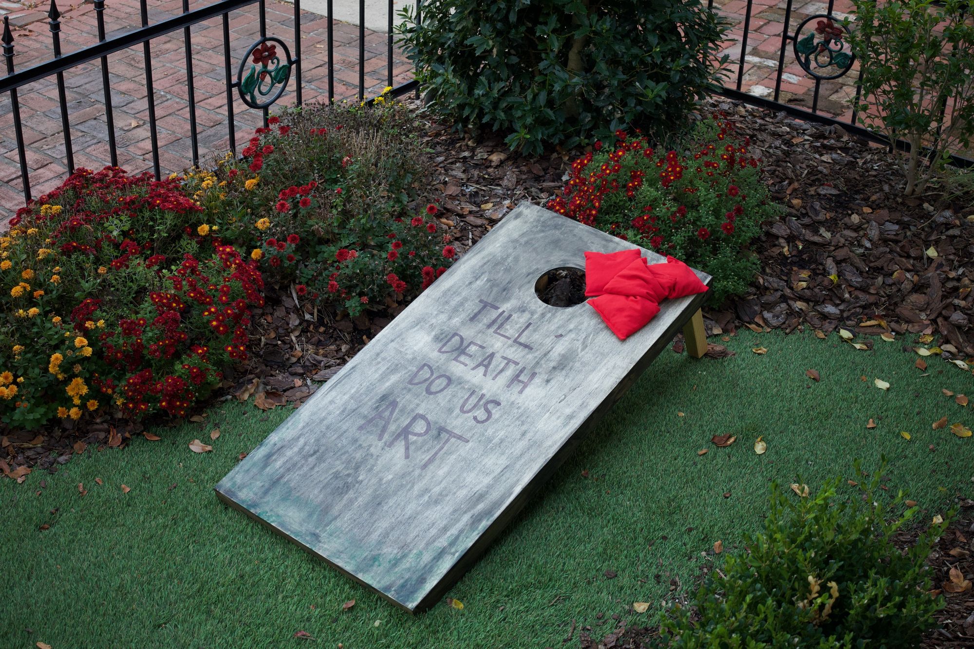 Cornhole board with "Till Death Do Us Art" written on it.