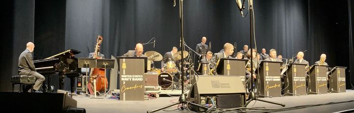 A panoramic image of the U.S. Navy Band Commodores playing onstage at the Saenger Theatre in Pensacola