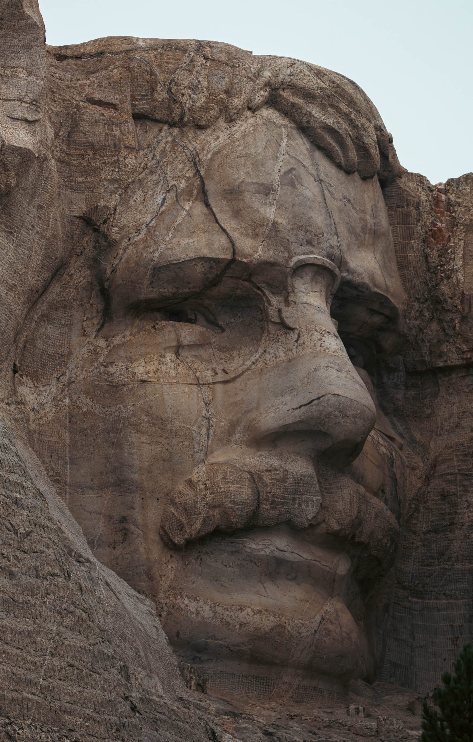 Close view of Theodore Roosevelt's carved face at Mount Rushmore, including his mustache and deeply recessed eyes.