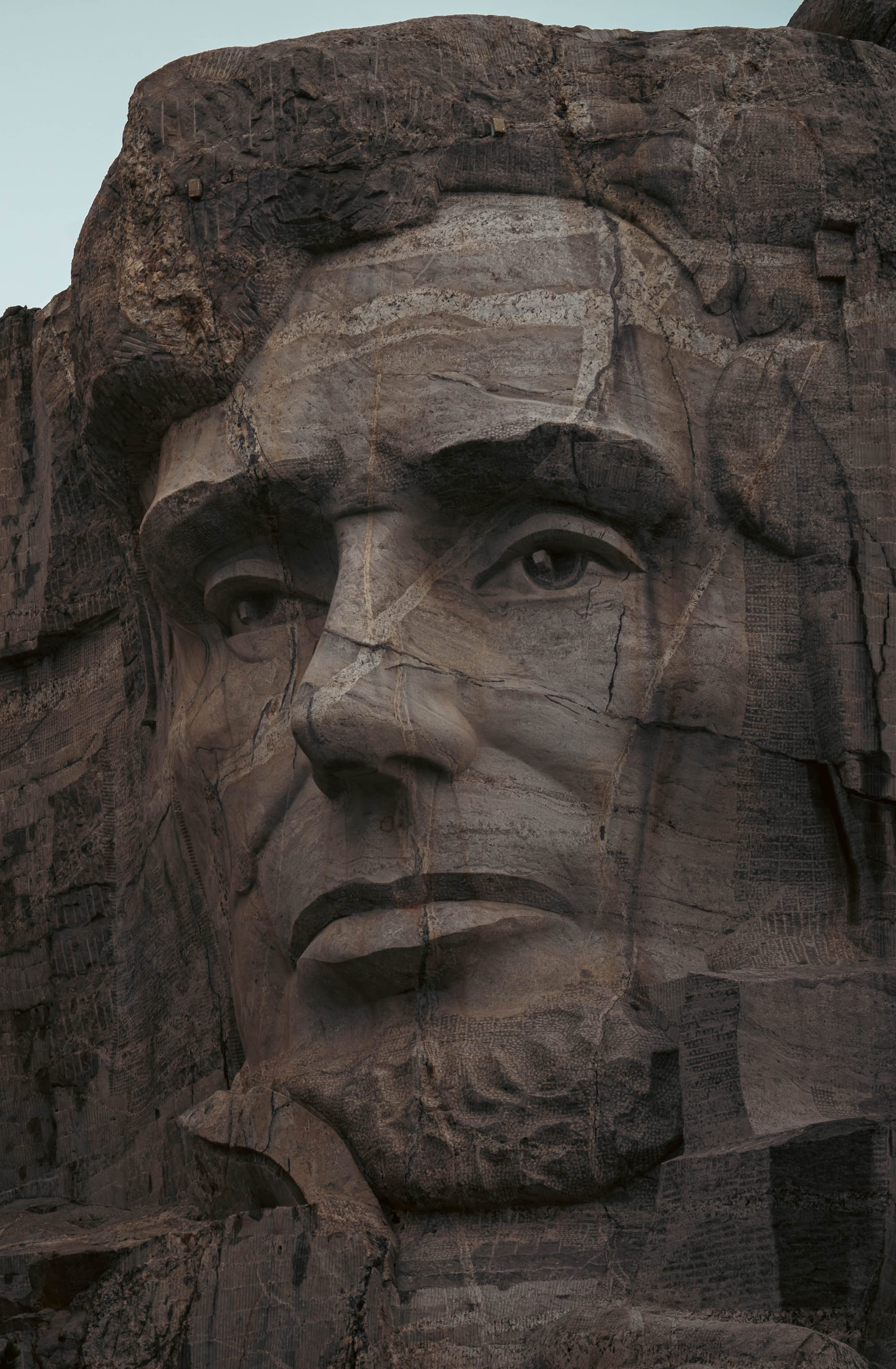 Close view of Abraham Lincoln's carved face showing the deep-set eyes and textured granite surface.