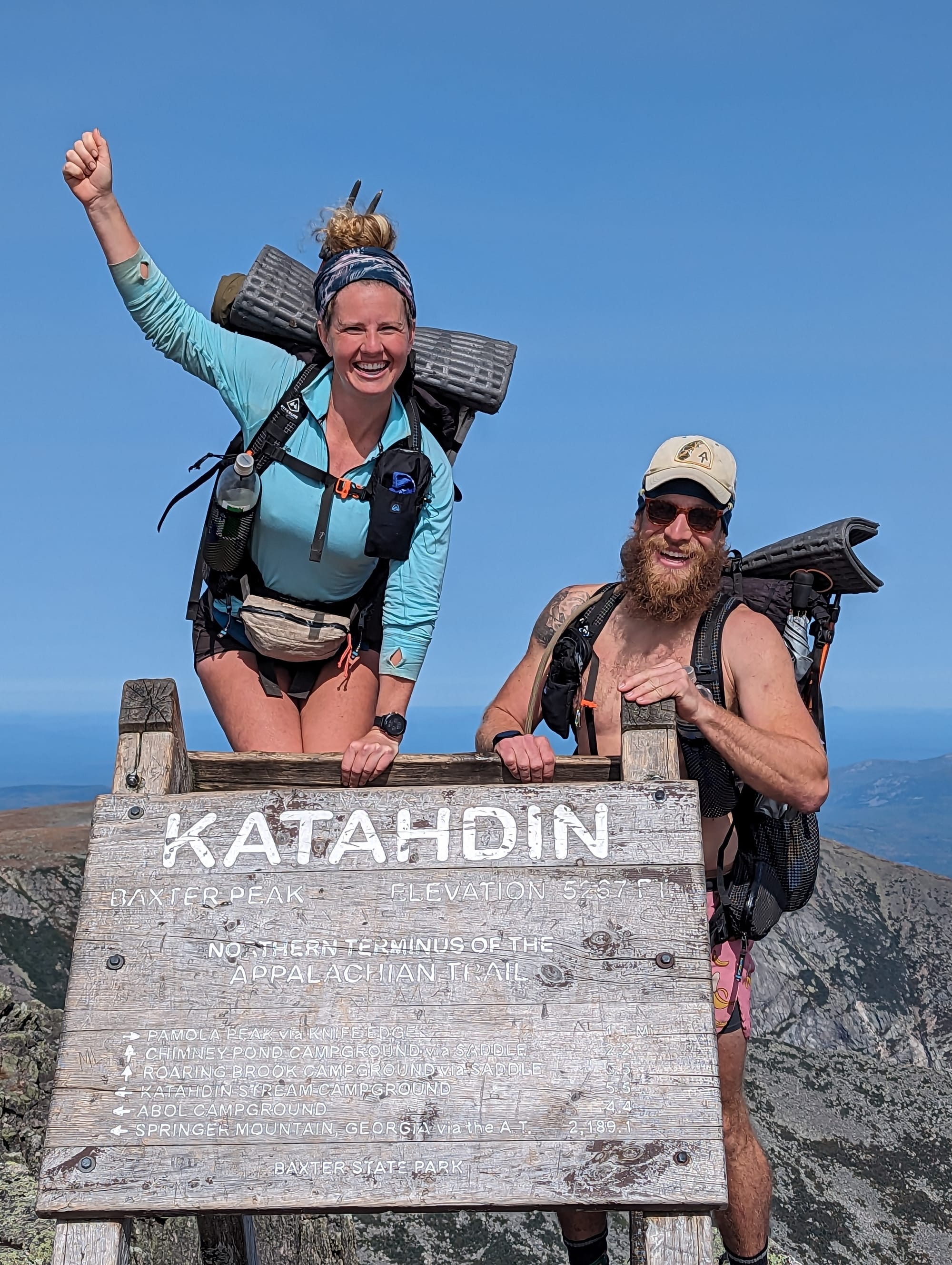 Brandon and Sunshine celebrating together at the Katahdin summit sign on Baxter Peak.